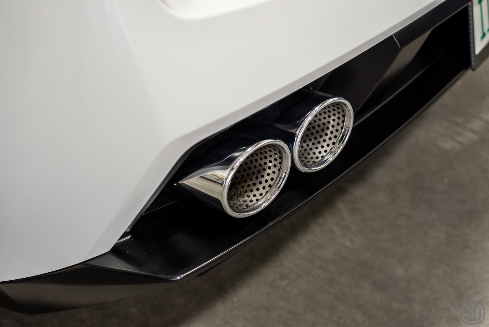A close up of the exhaust pipes on the back of a car.