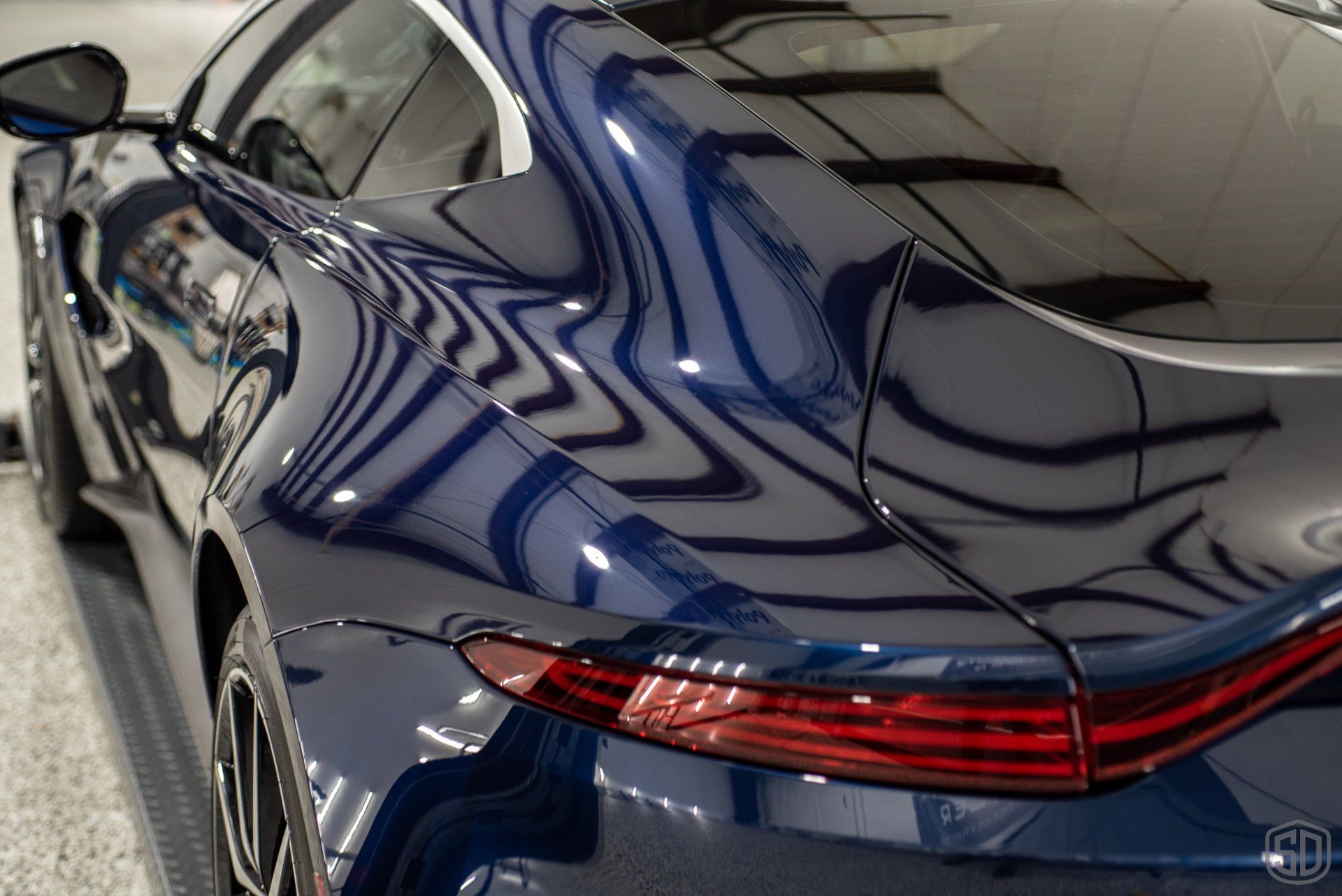 A blue sports car is parked in a garage.
