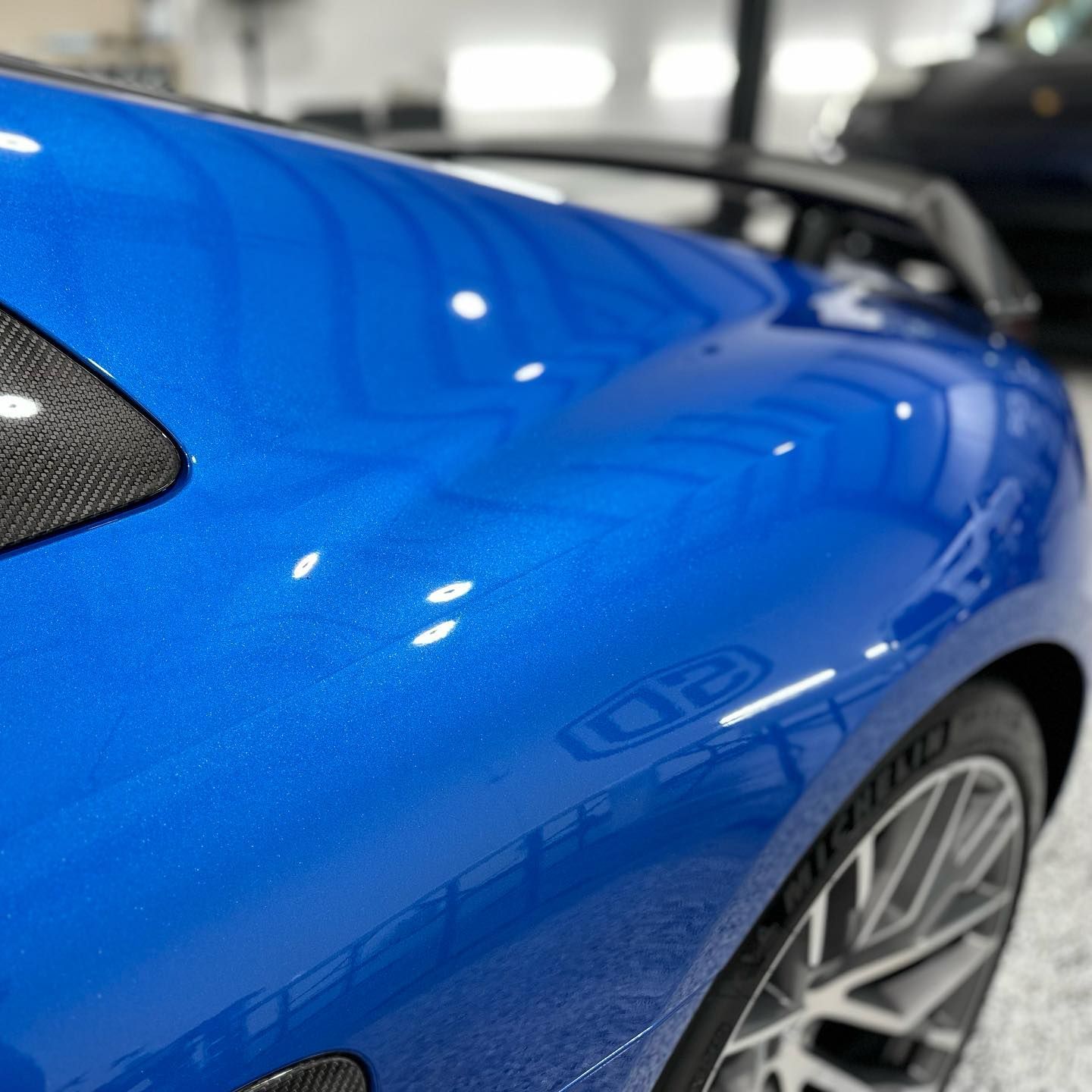 A close up of the side of a blue sports car