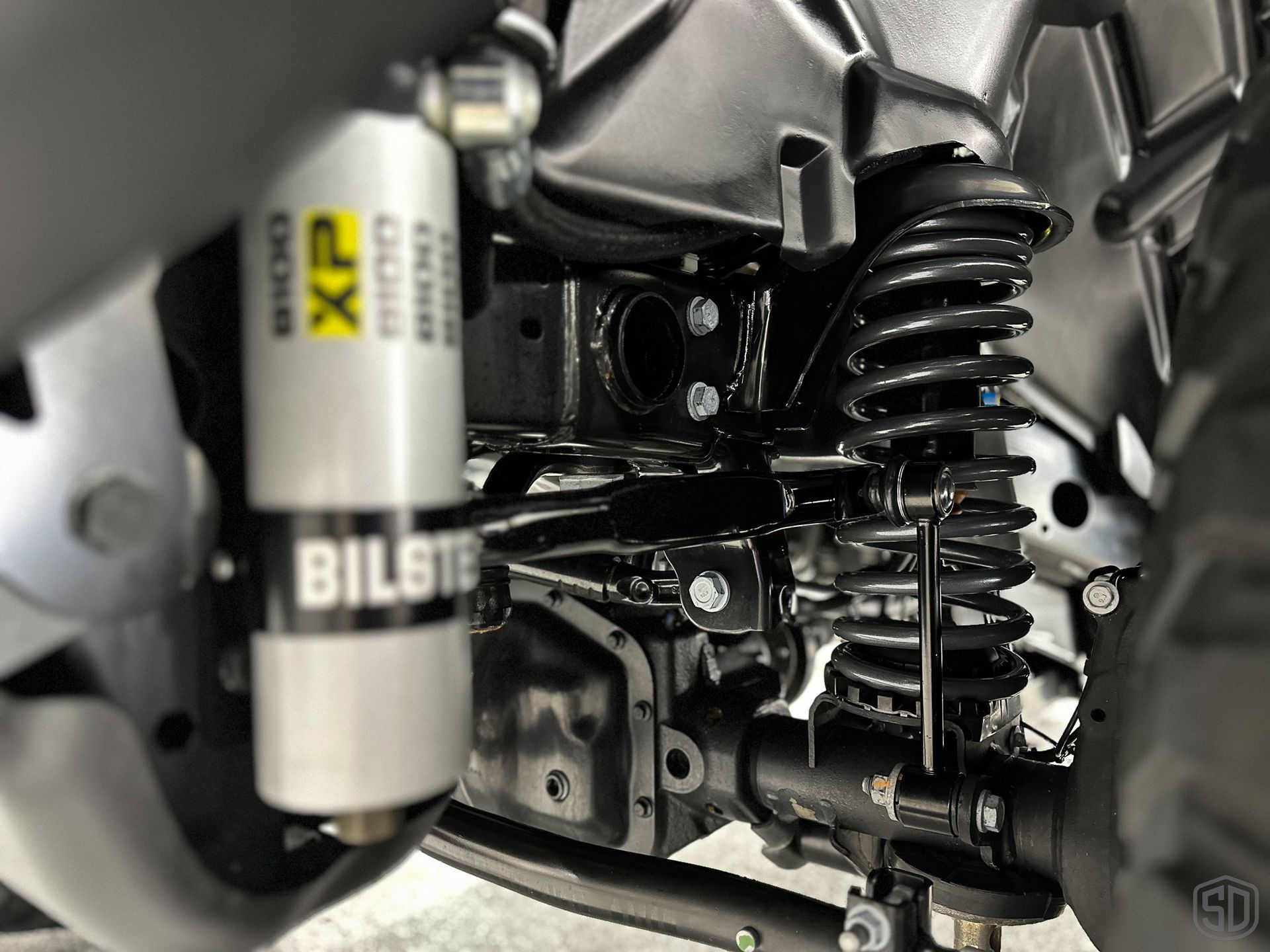 A close up of a bilstein shock absorber on a vehicle