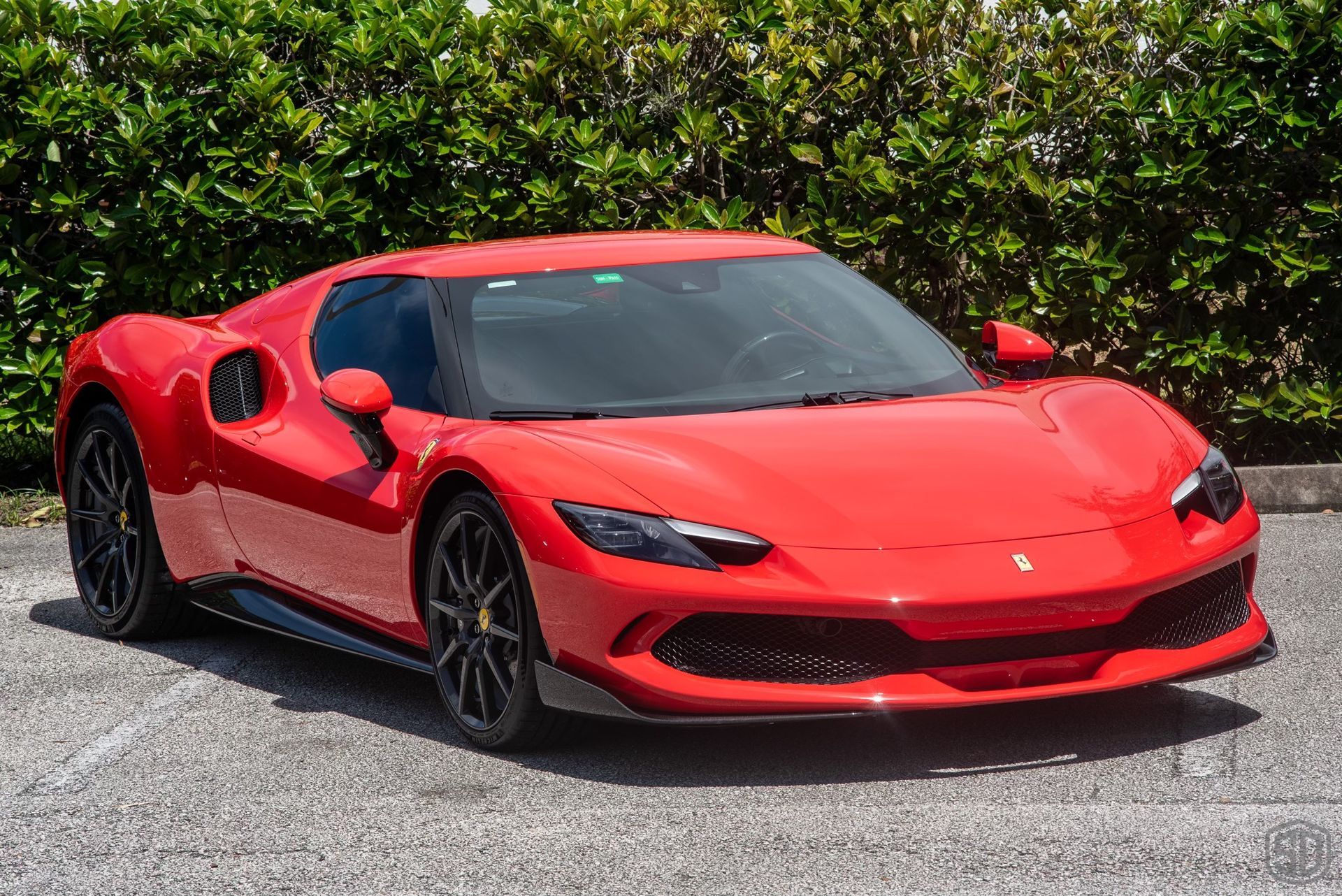A red ferrari sports car is parked in a parking lot.