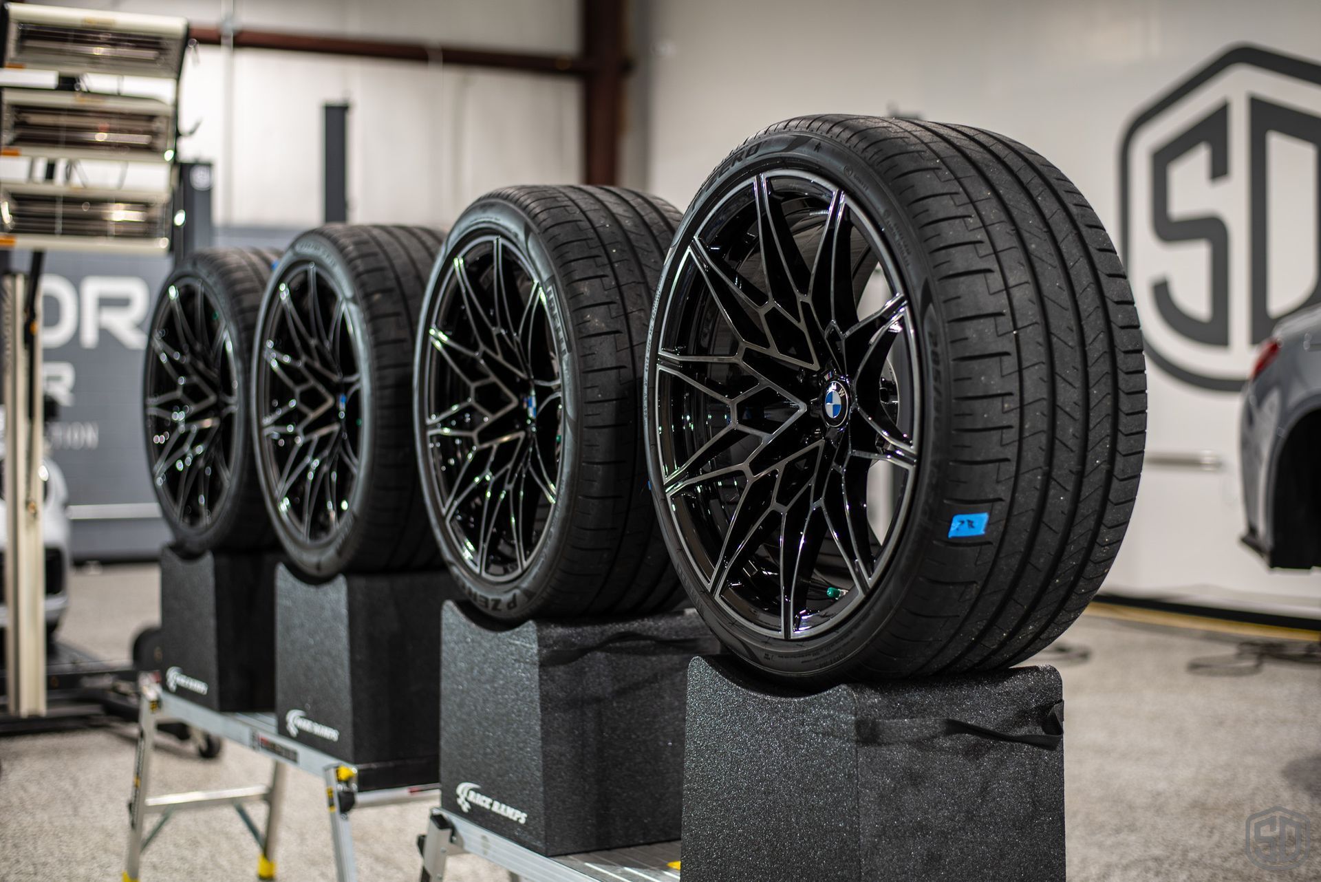 A row of tires are stacked on top of each other in a garage.