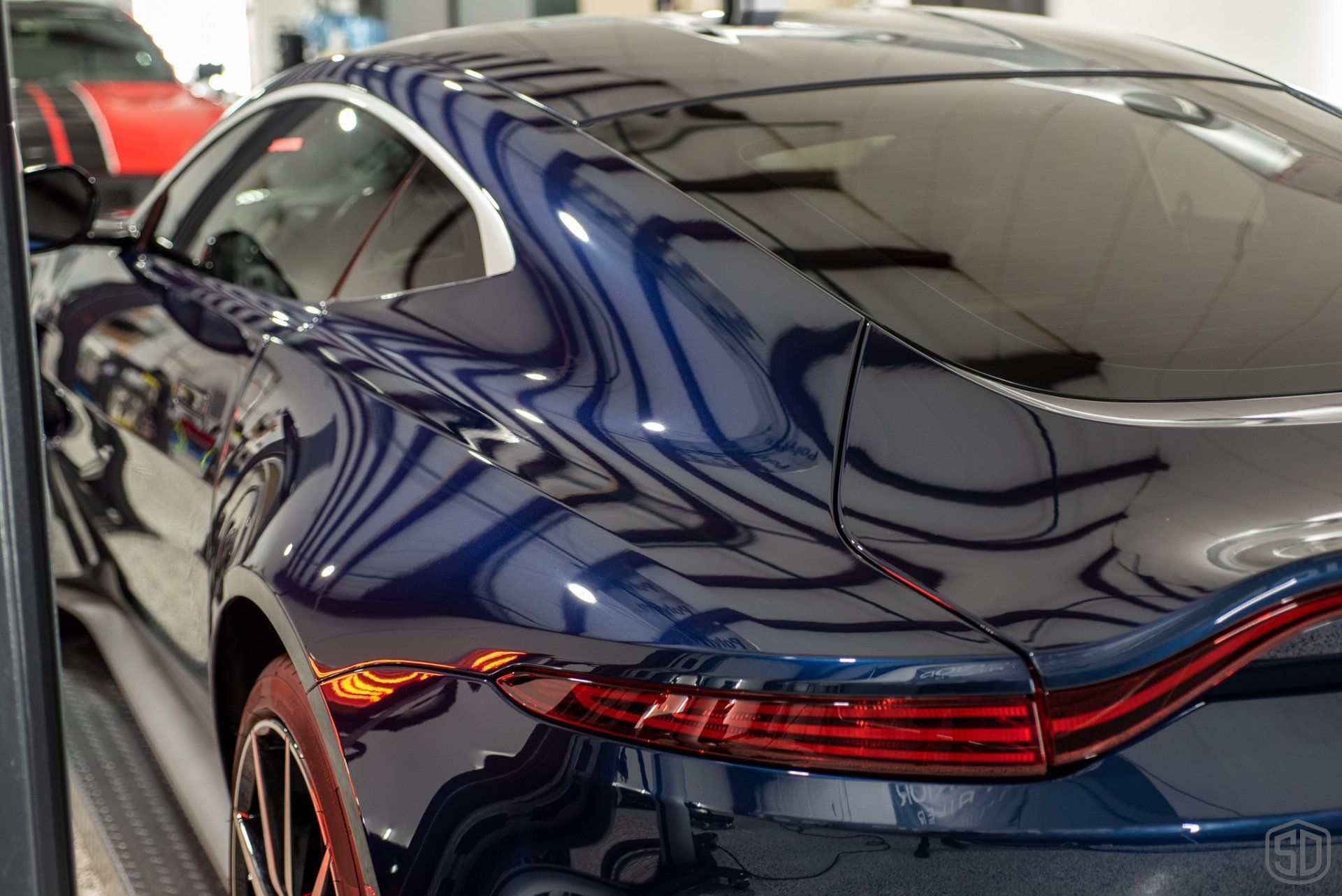 A blue sports car is parked in a parking lot.