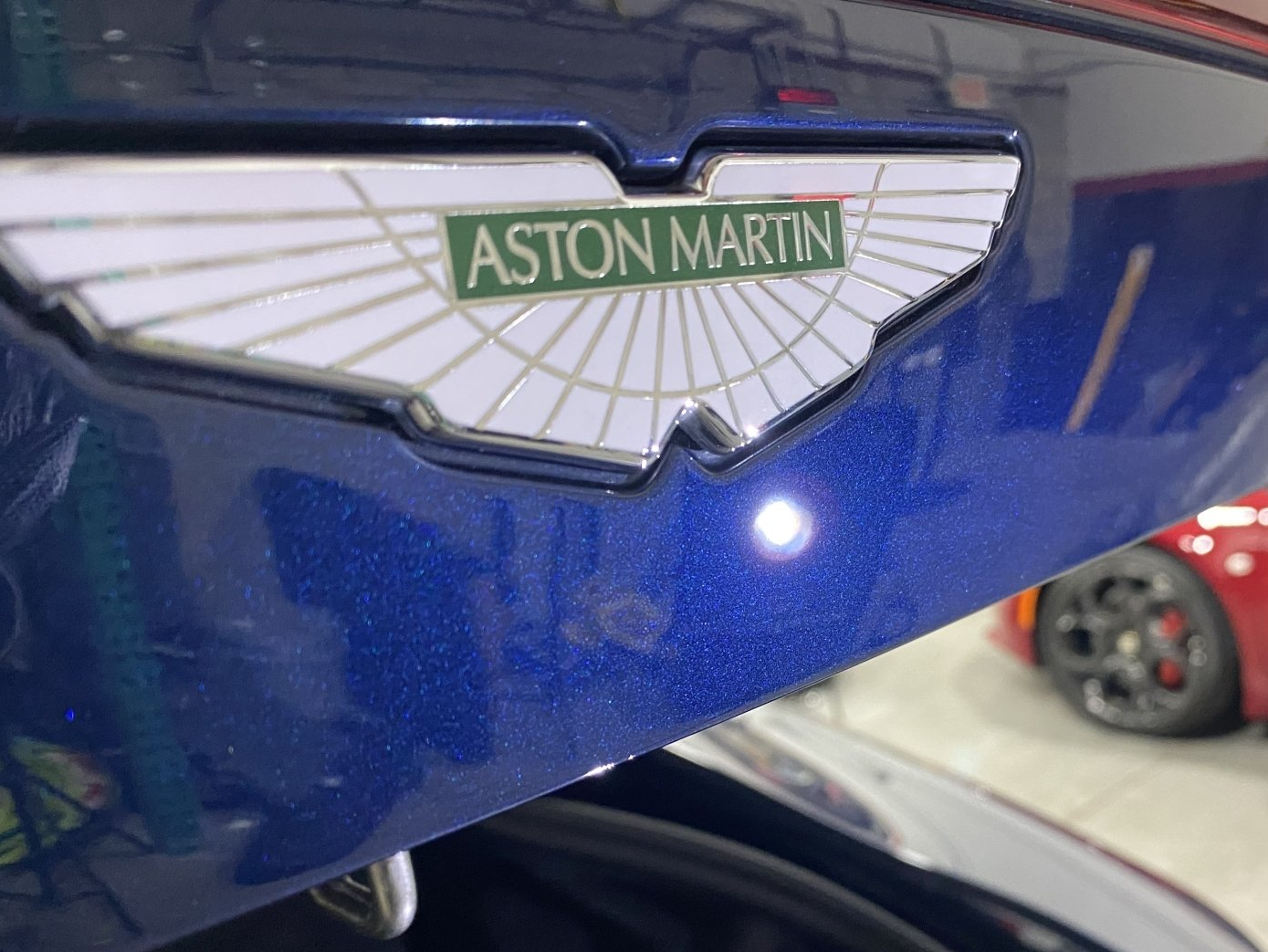 A blue aston martin car is parked in a garage