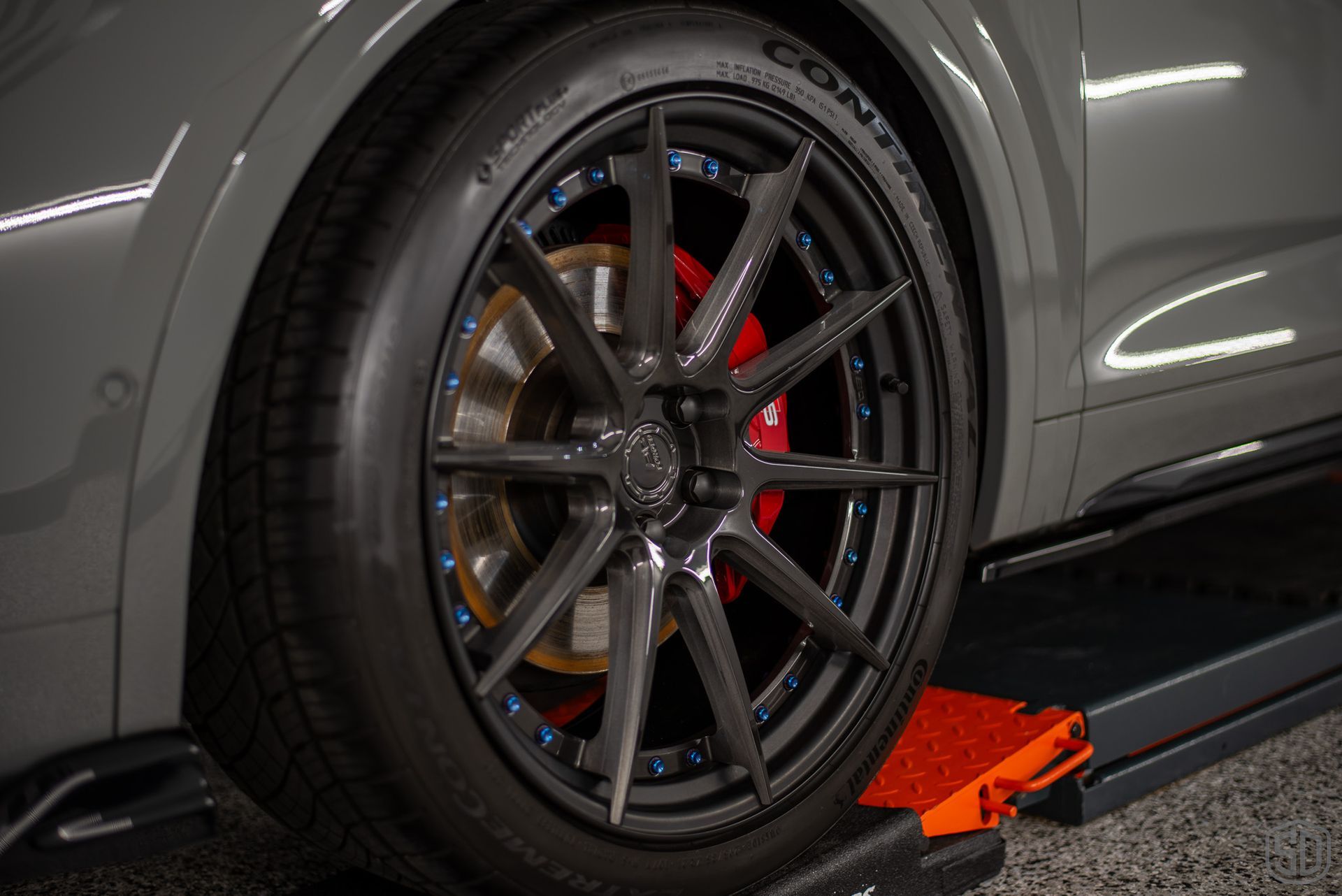 A close up of a car wheel on a lift.