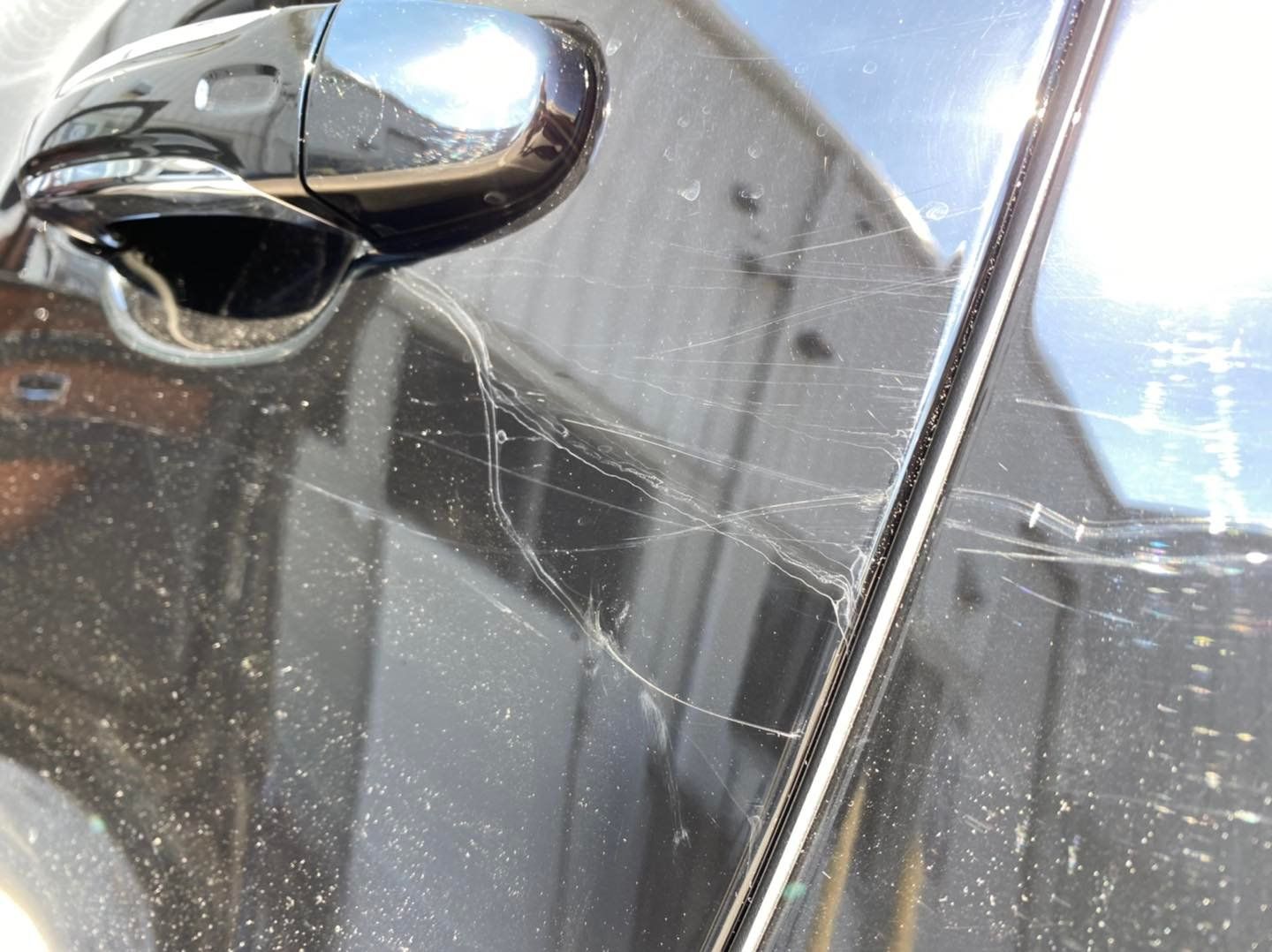 A close up of a car door with a spider web on it