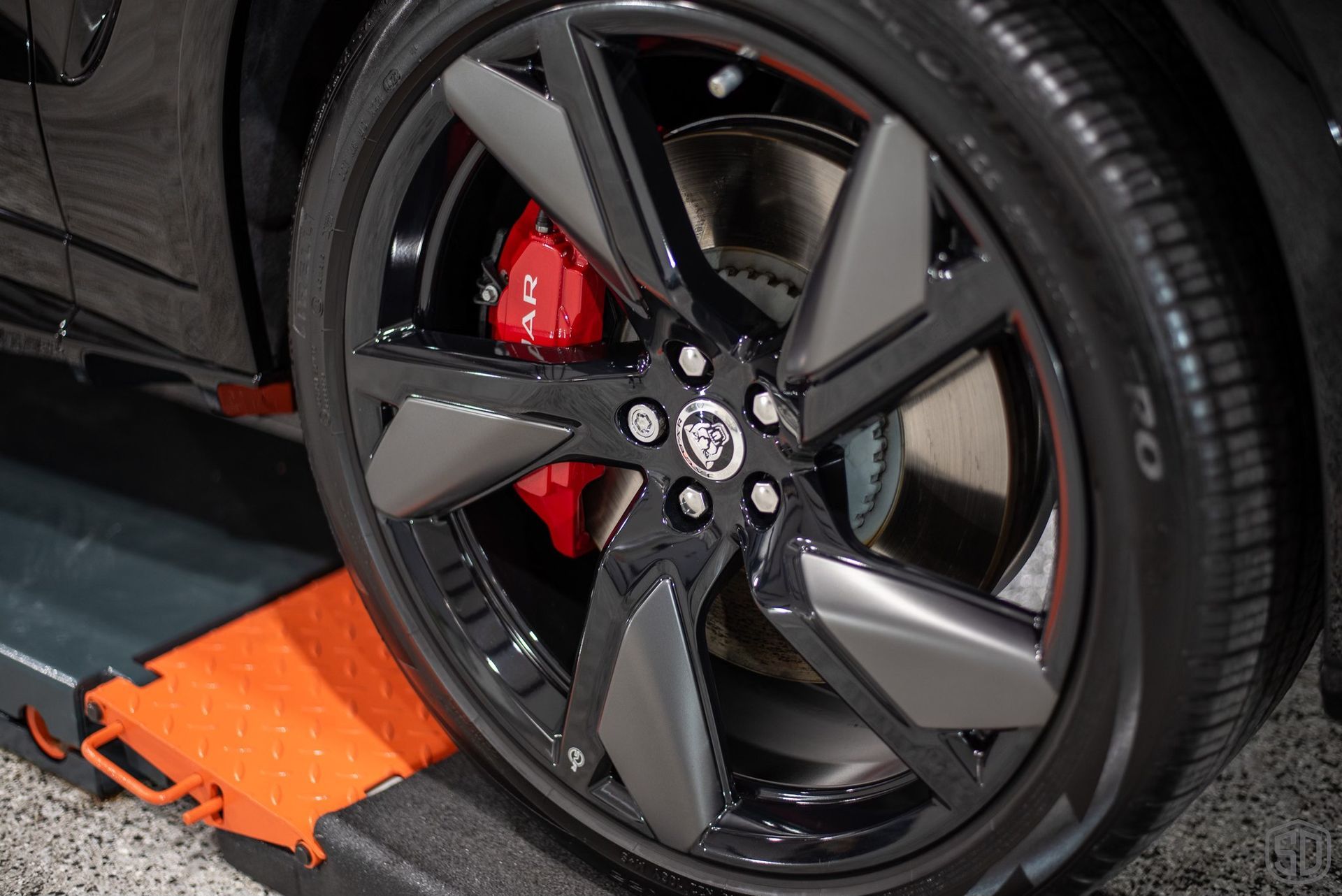 A close up of a car wheel with red brake calipers.