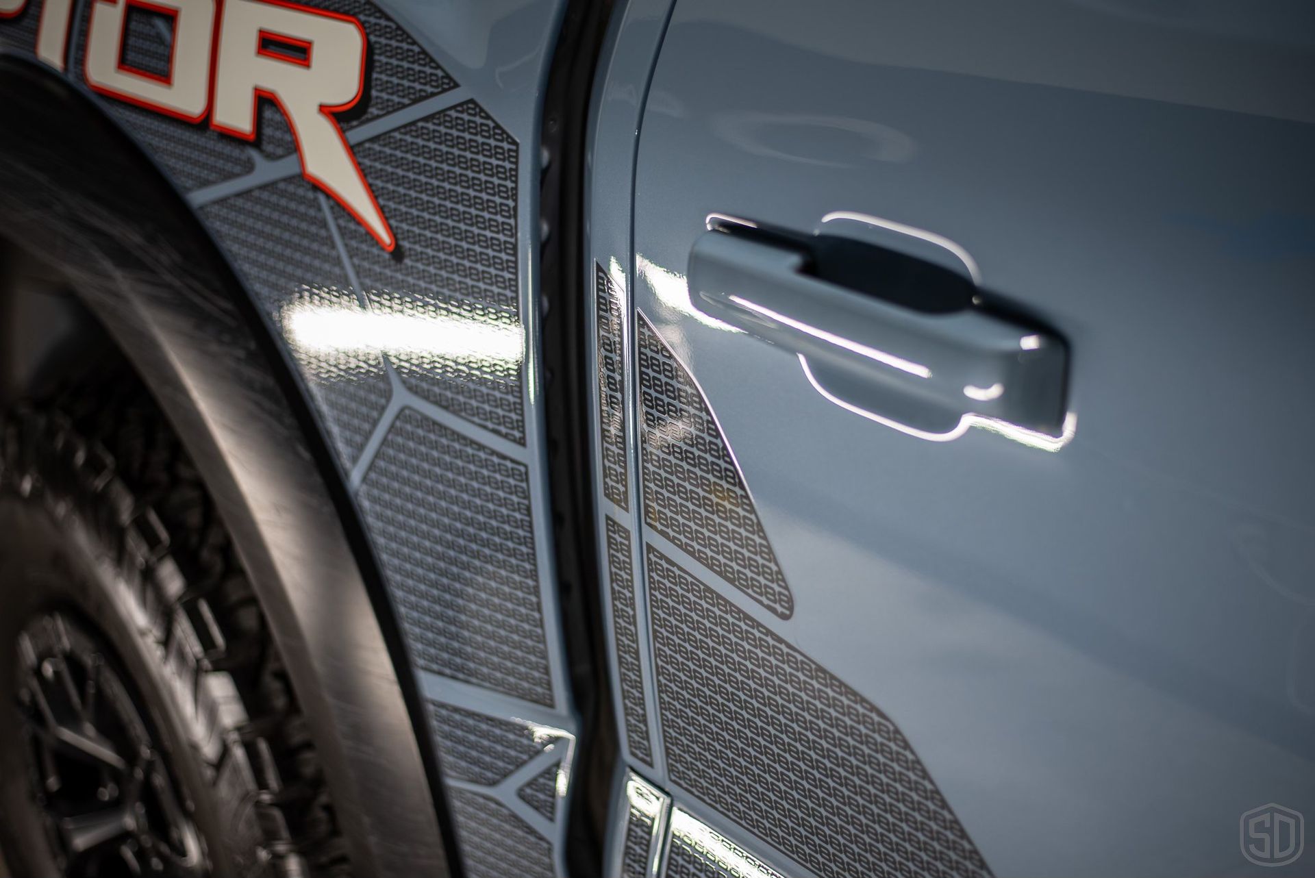 A close up of the door handle of a ford raptor truck.