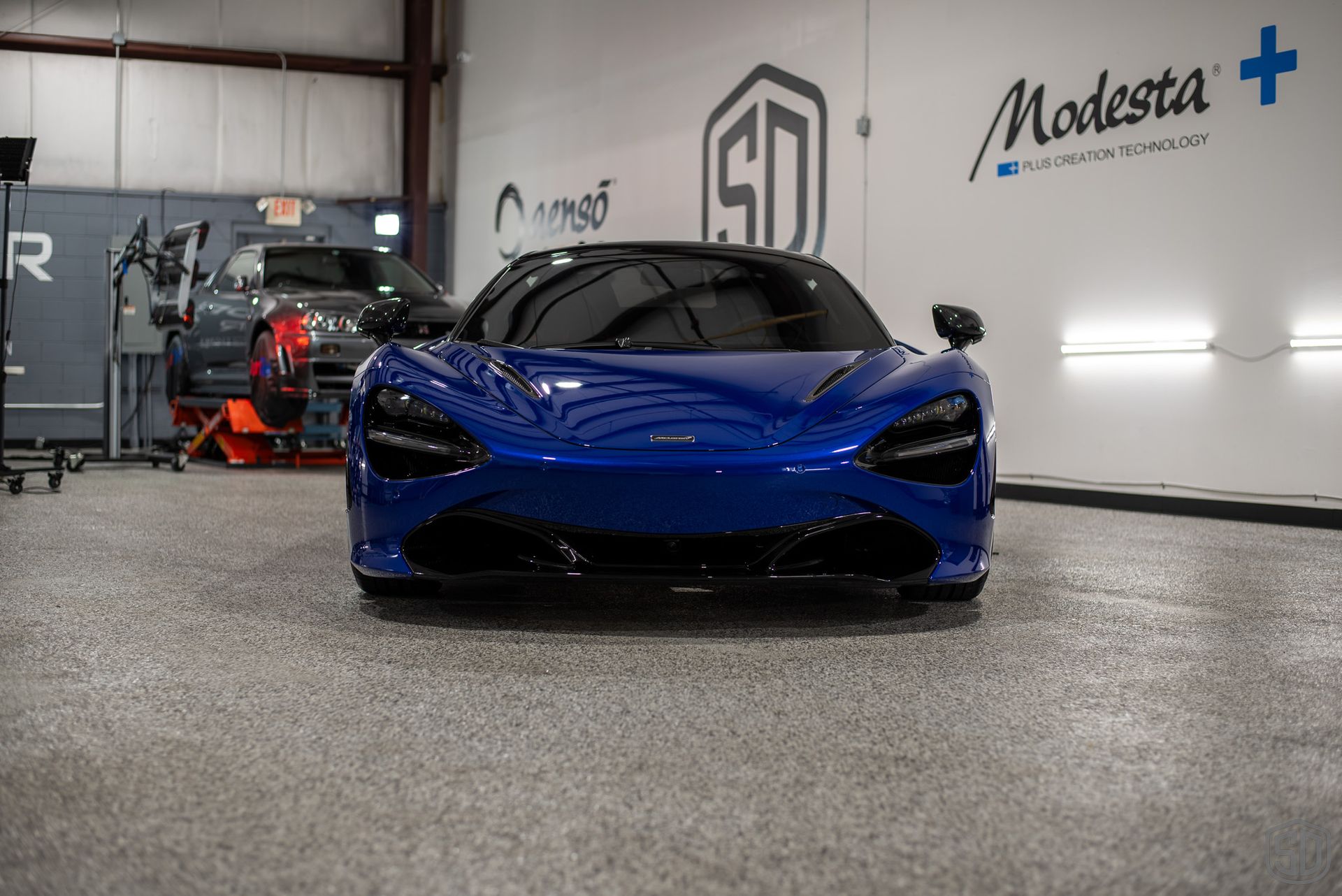 A blue sports car is parked in a garage.