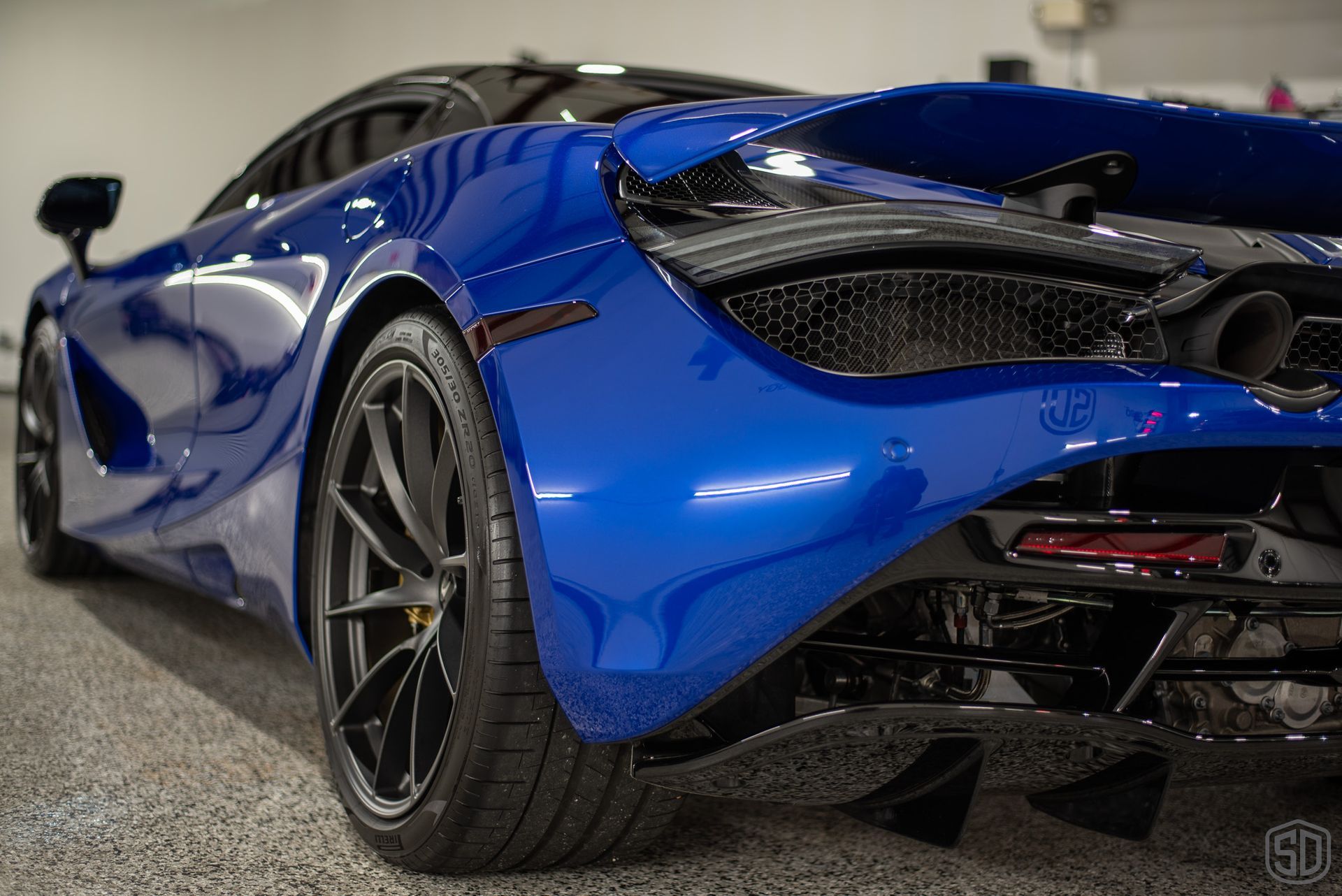 A blue sports car is parked in a garage.
