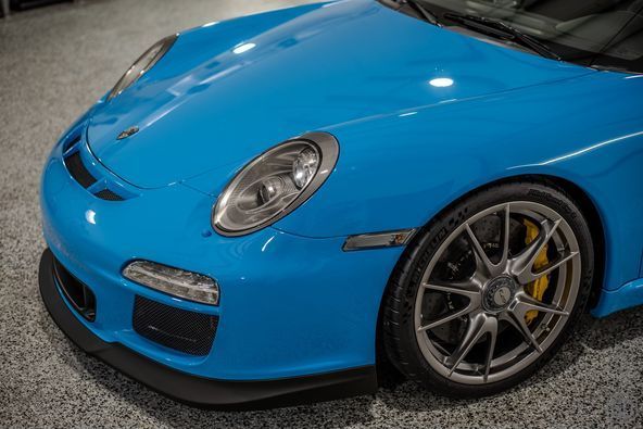 A blue porsche 911 gt3 rs is parked in a garage.