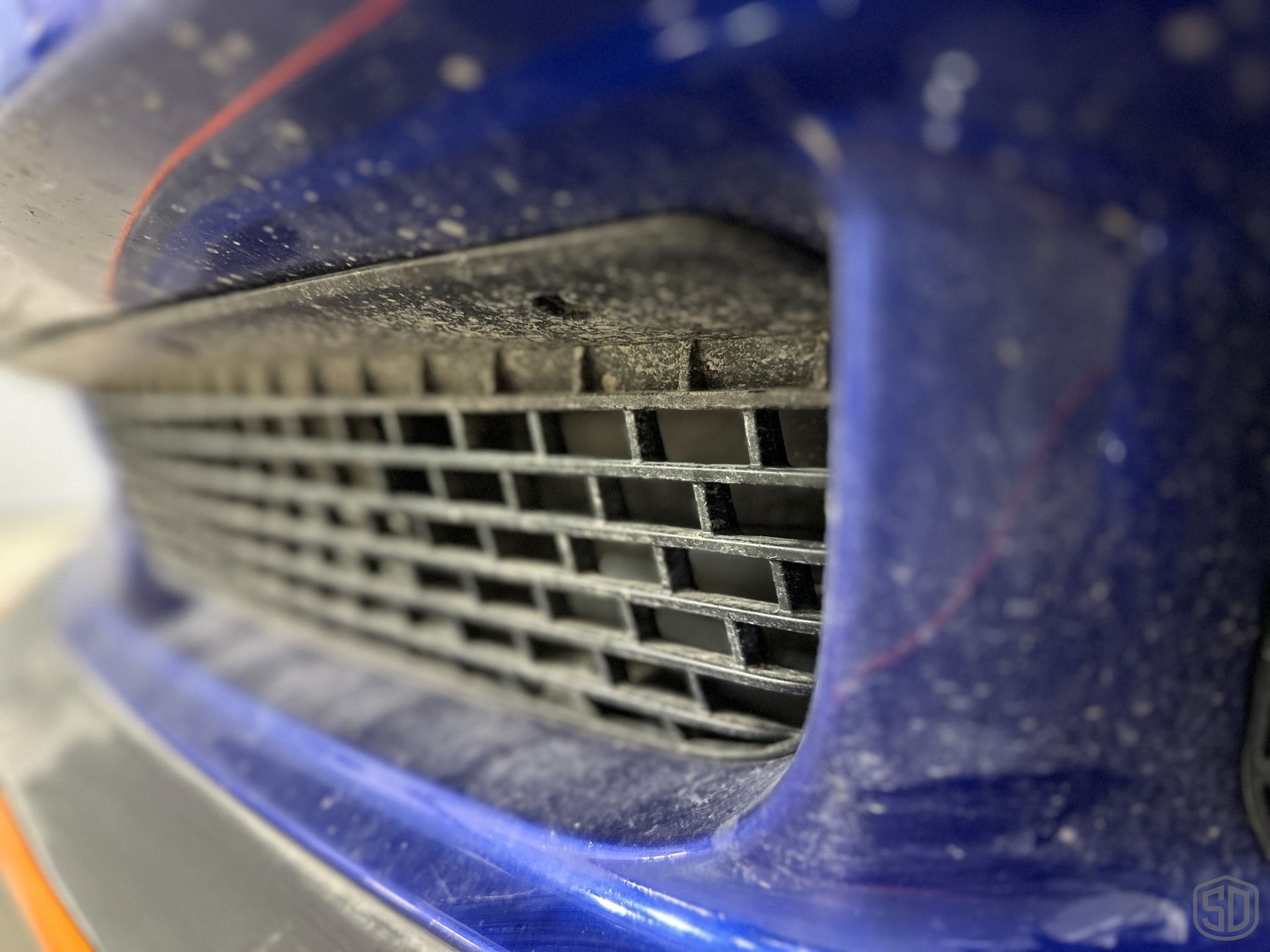 A close up of the front bumper of a blue car
