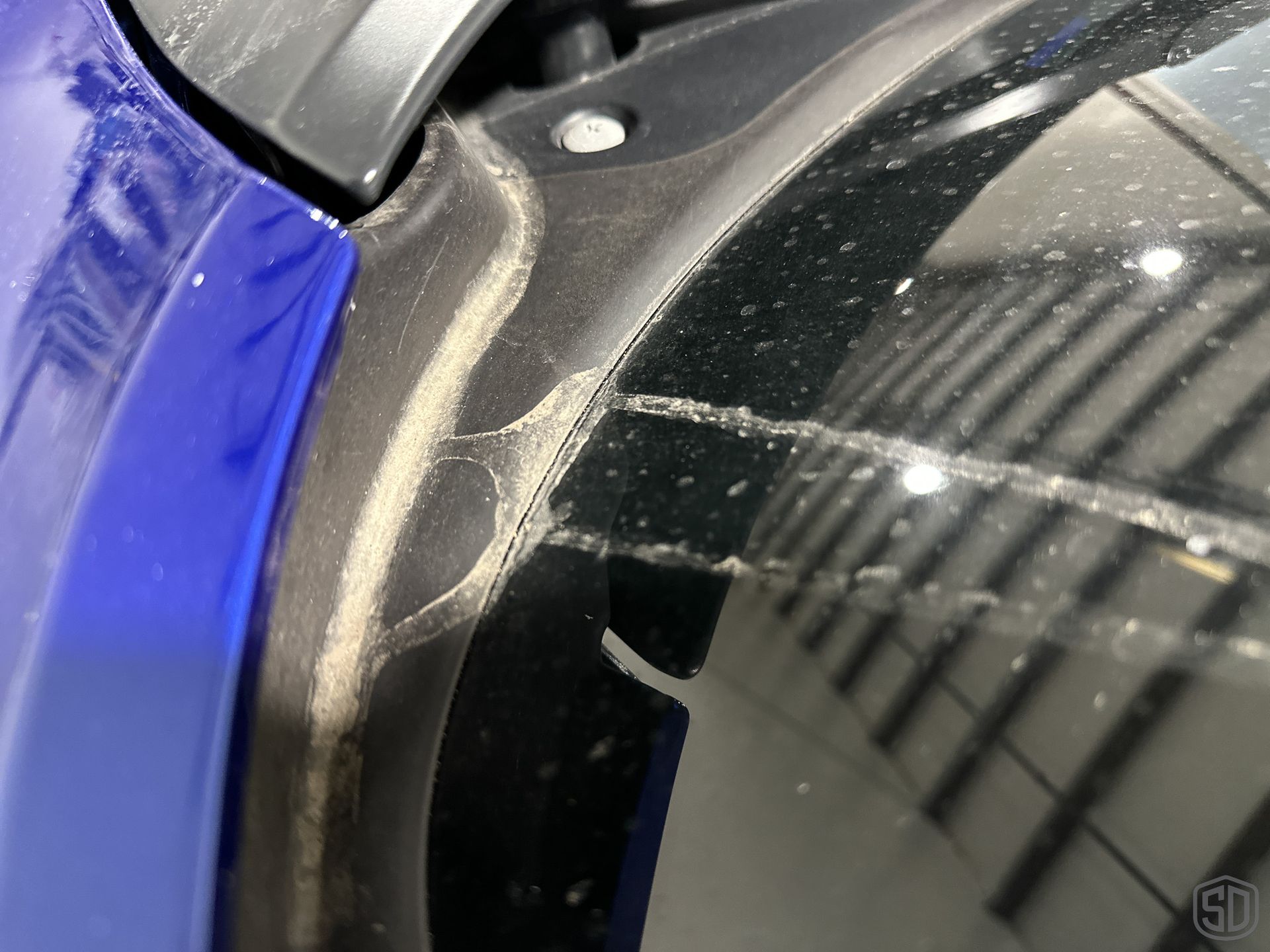 A close up of a blue car with a broken windshield