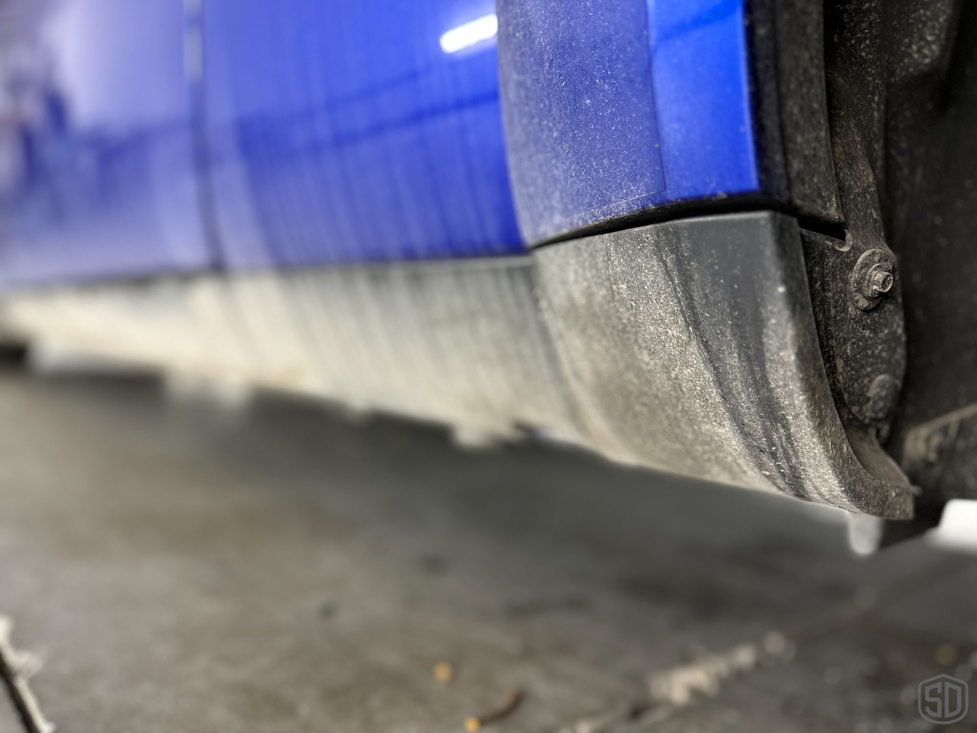 A black car is parked in a garage.