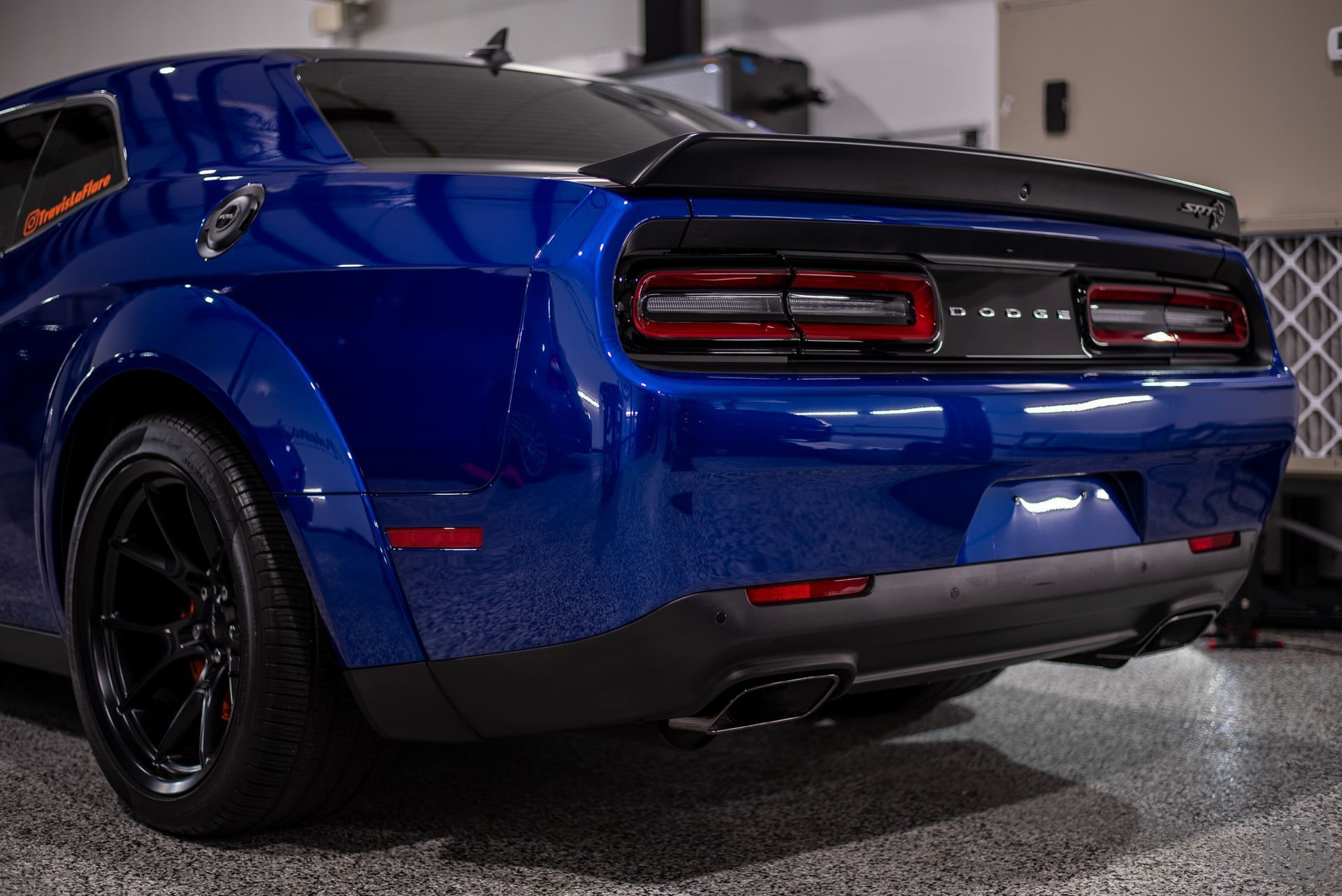 A blue dodge challenger is parked in a garage.