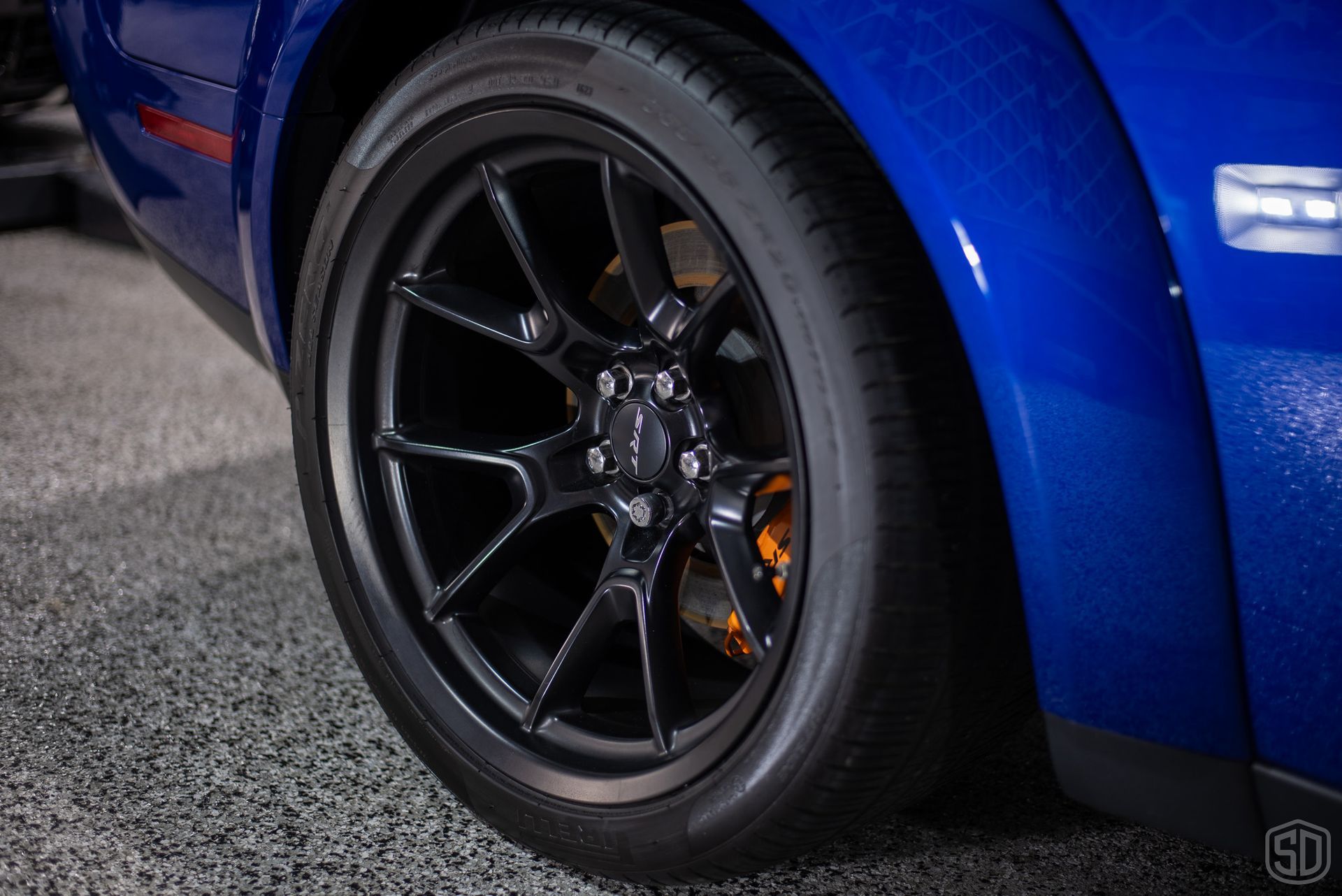 A close up of a blue car with black wheels and tires