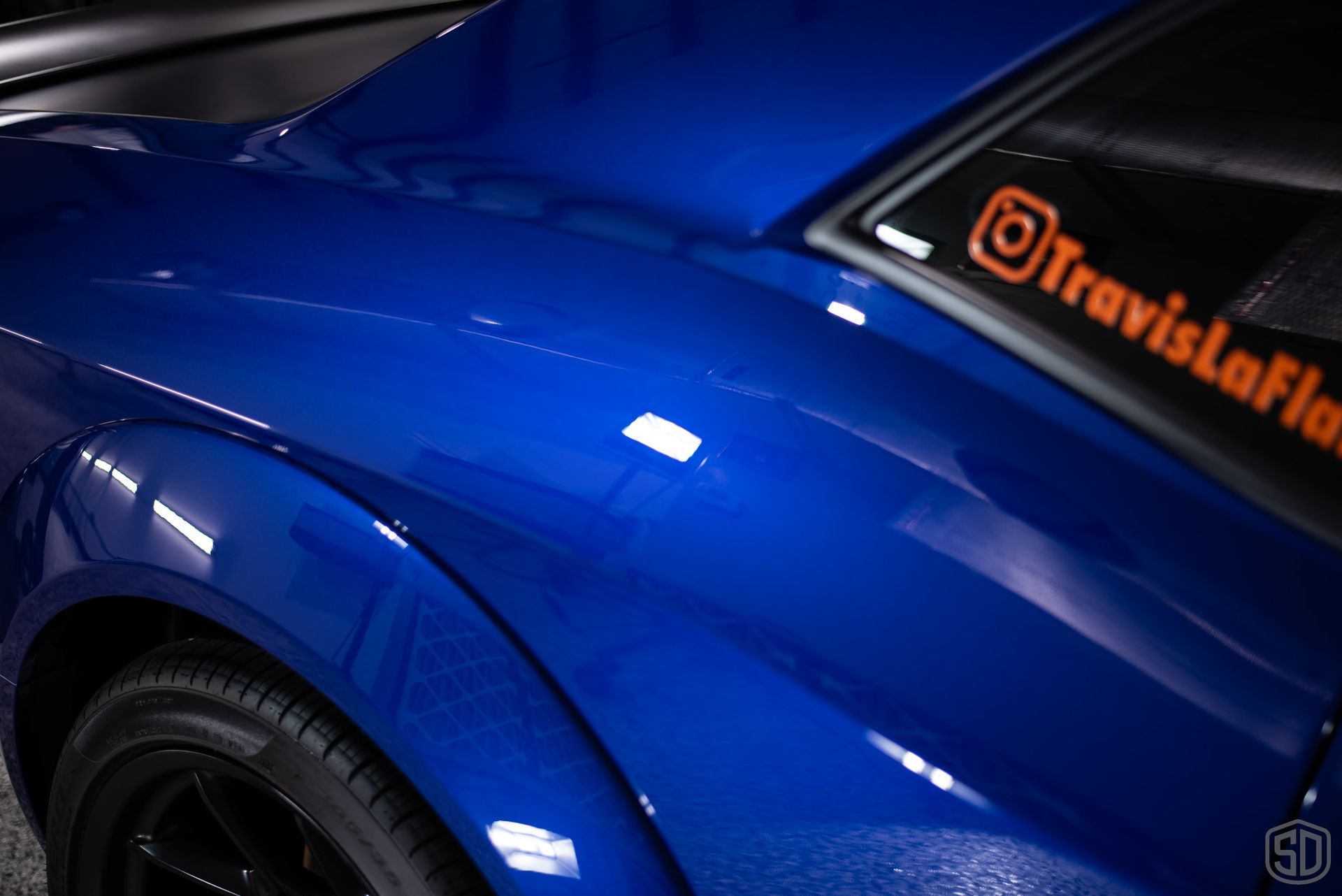 A blue car with a sticker on the side that says travislafla