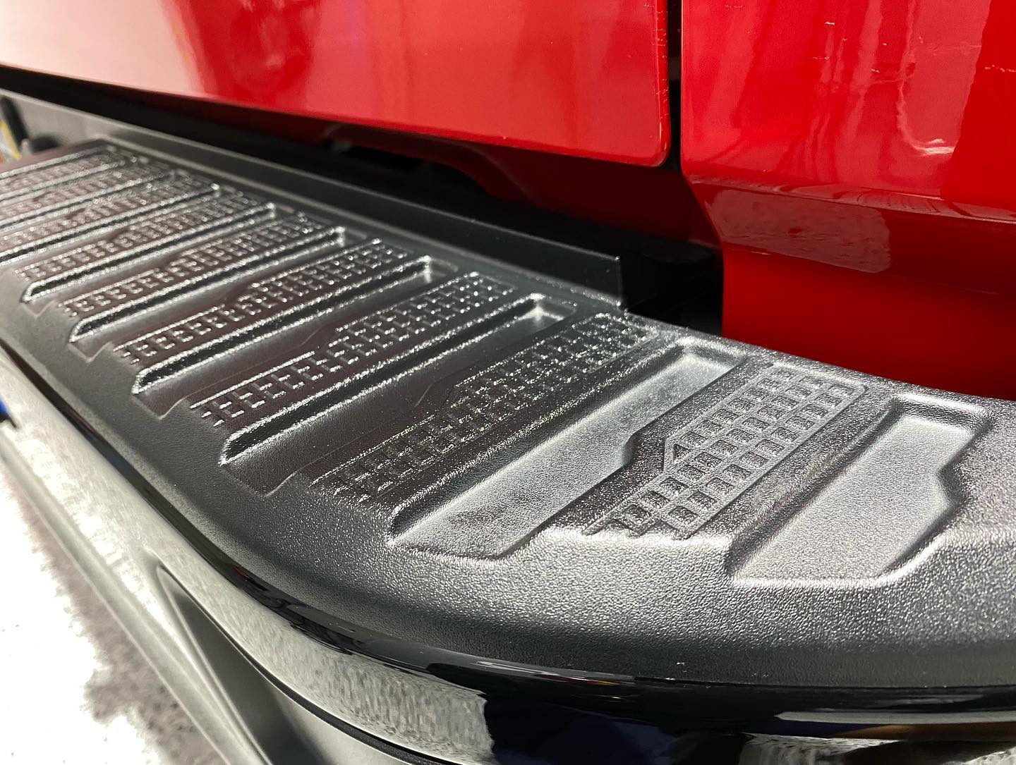 A close up of the back bumper of a red truck.