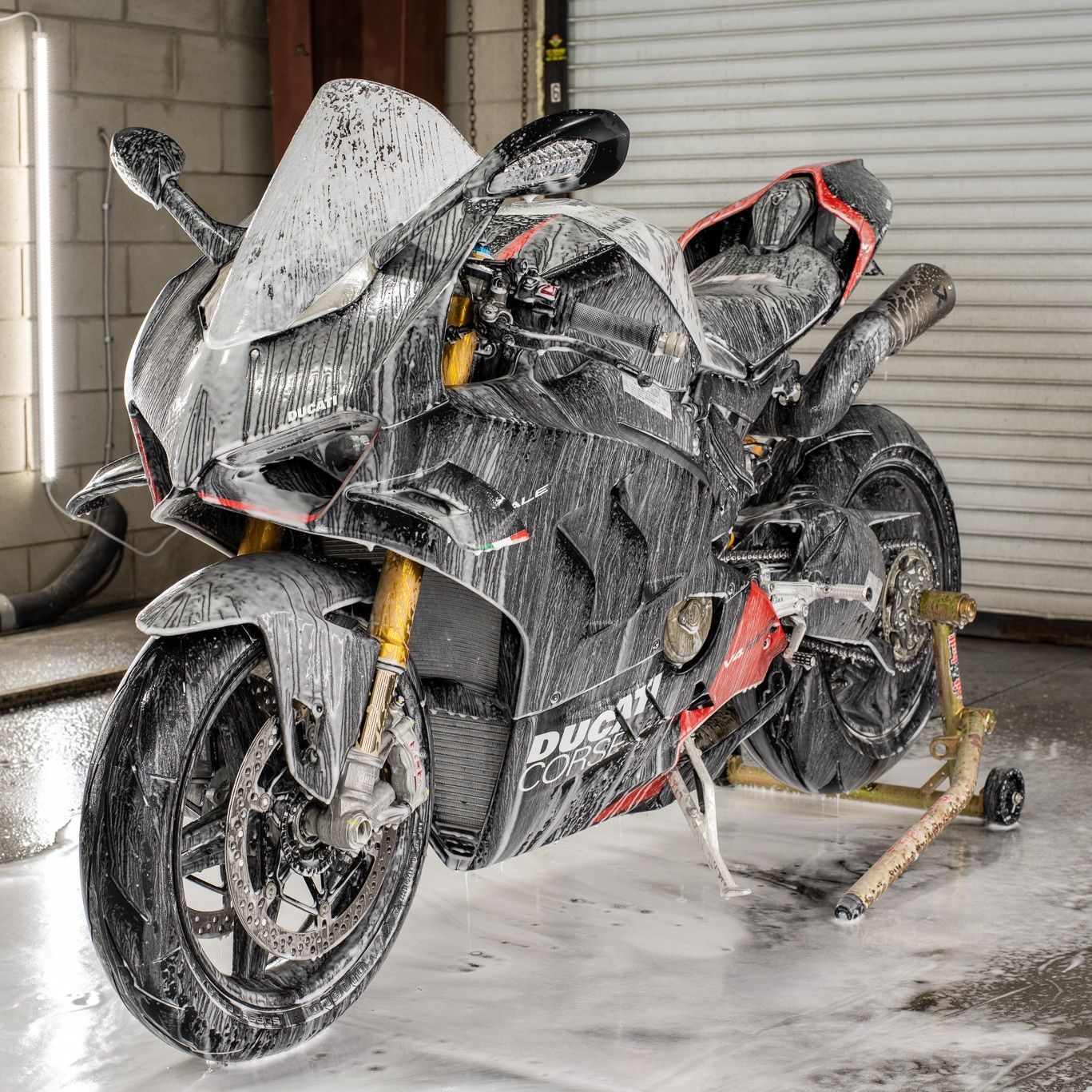 A motorcycle is covered in foam in a garage.