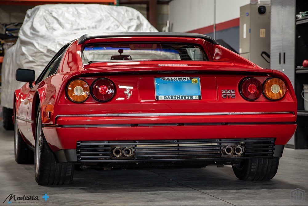 A red ferrari sports car is parked in a garage.