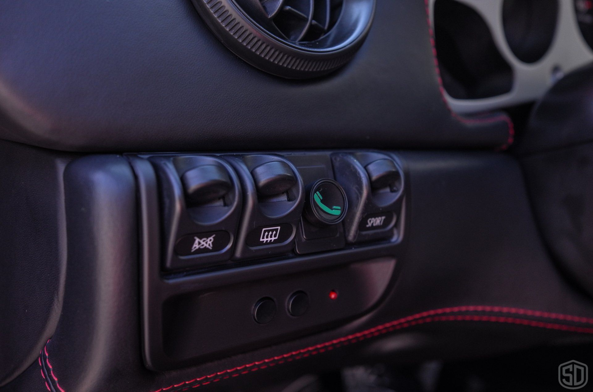 A close up of a car dashboard with a bunch of buttons on it.
