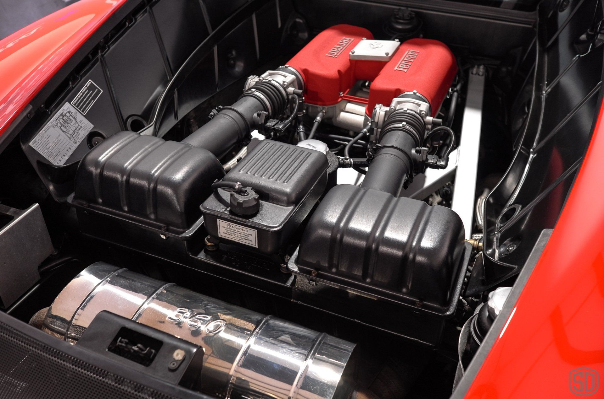 The engine of a red sports car with the hood open