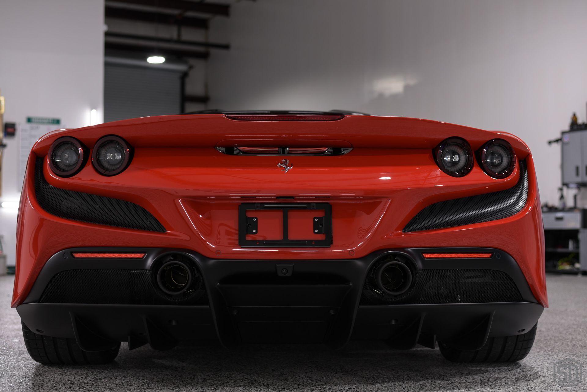 A red ferrari sports car is parked in a garage.