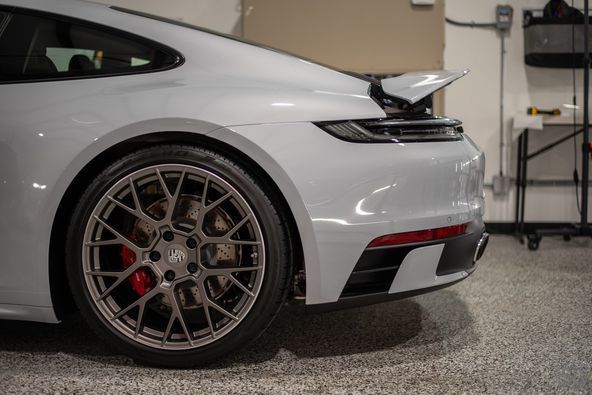 A white porsche 911 is parked in a garage.