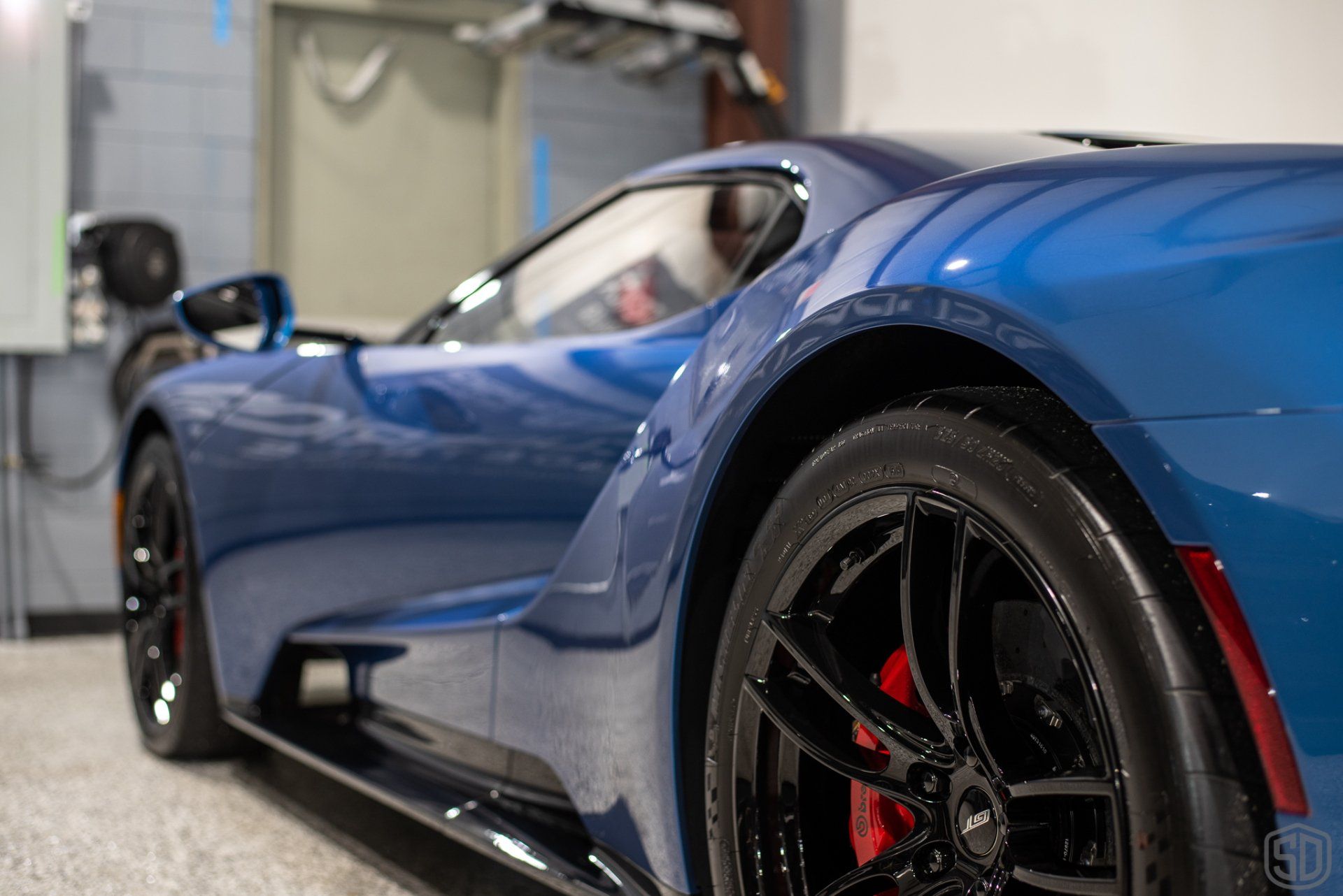 A blue sports car is parked in a garage.