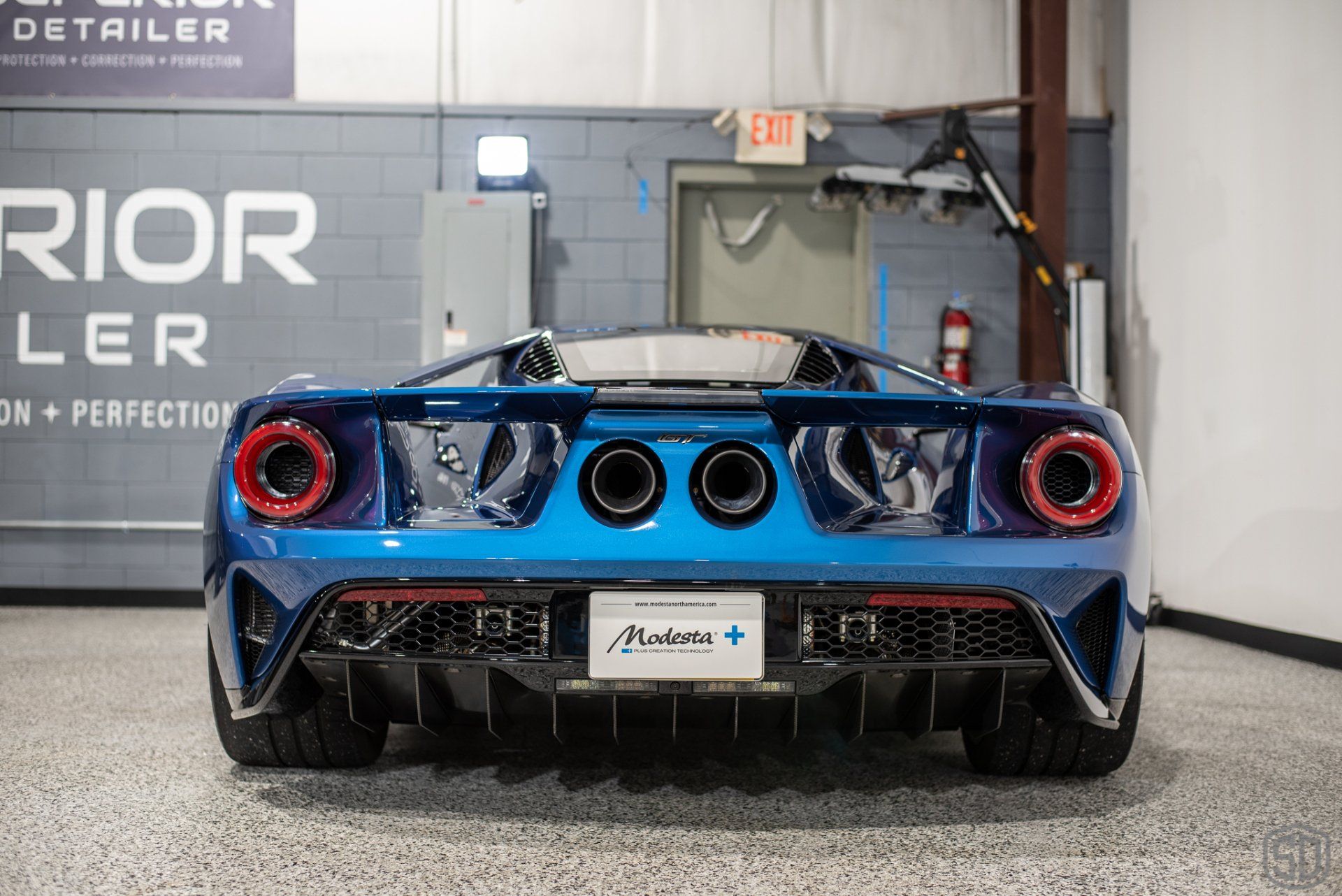 A blue ford gt is parked in a garage.