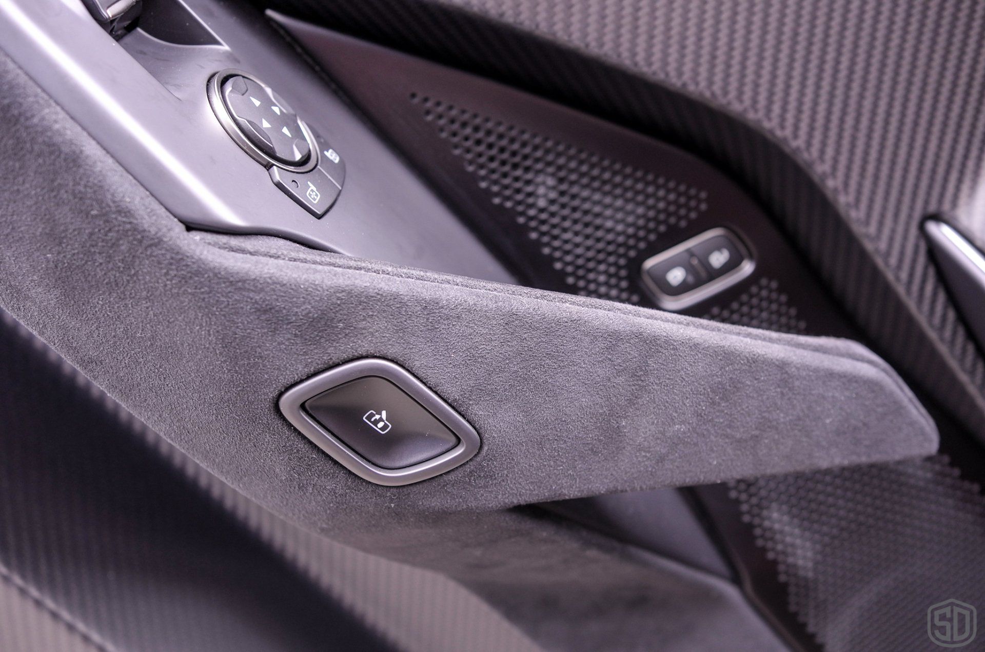 A close up of a car door handle with buttons and a speaker