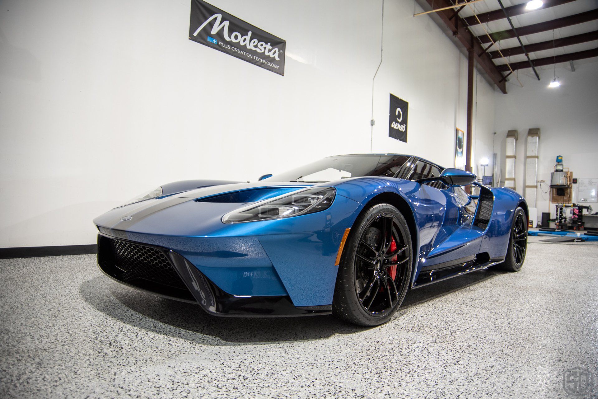 A blue ford gt is parked in a garage.