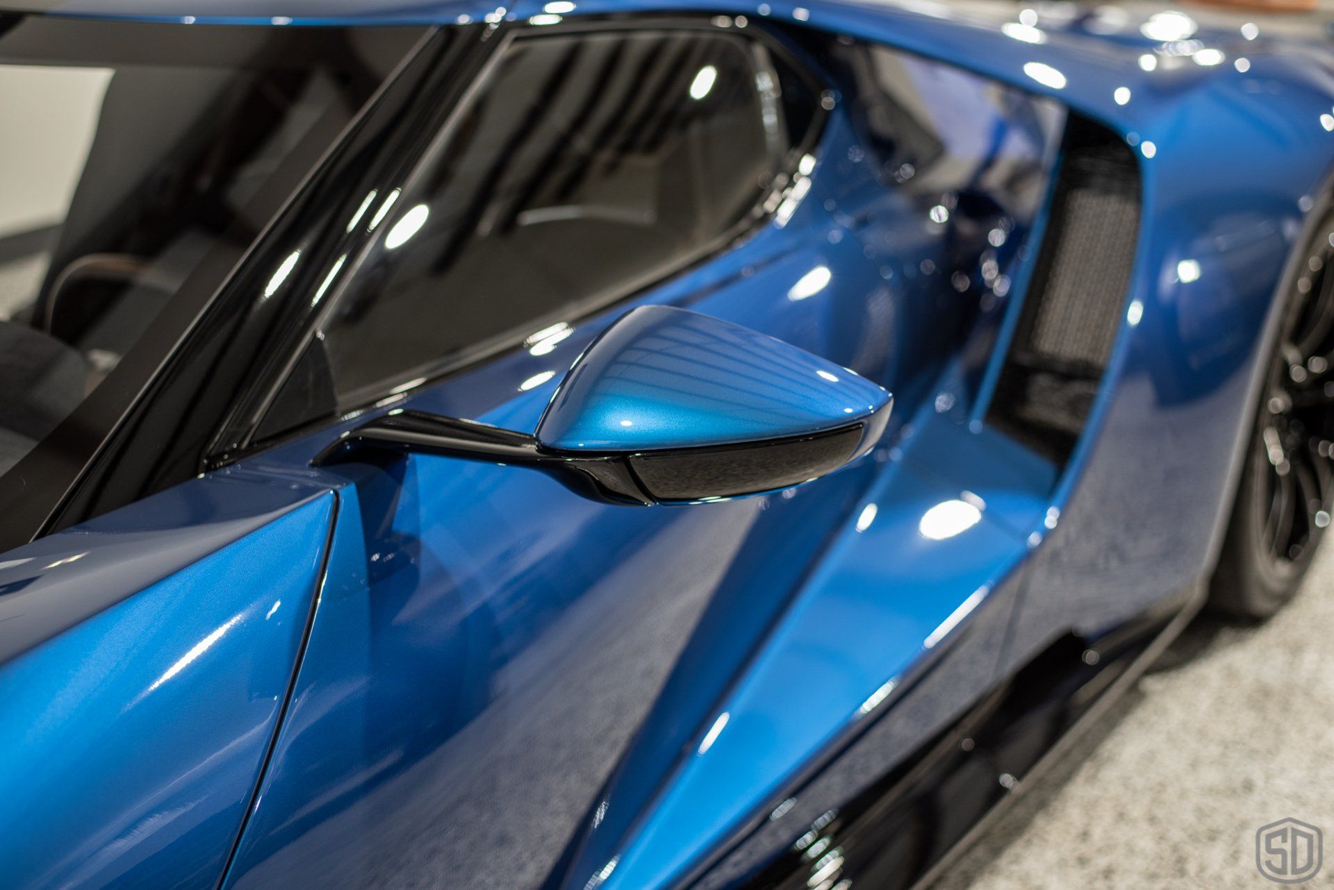 A blue sports car is parked on a concrete floor.