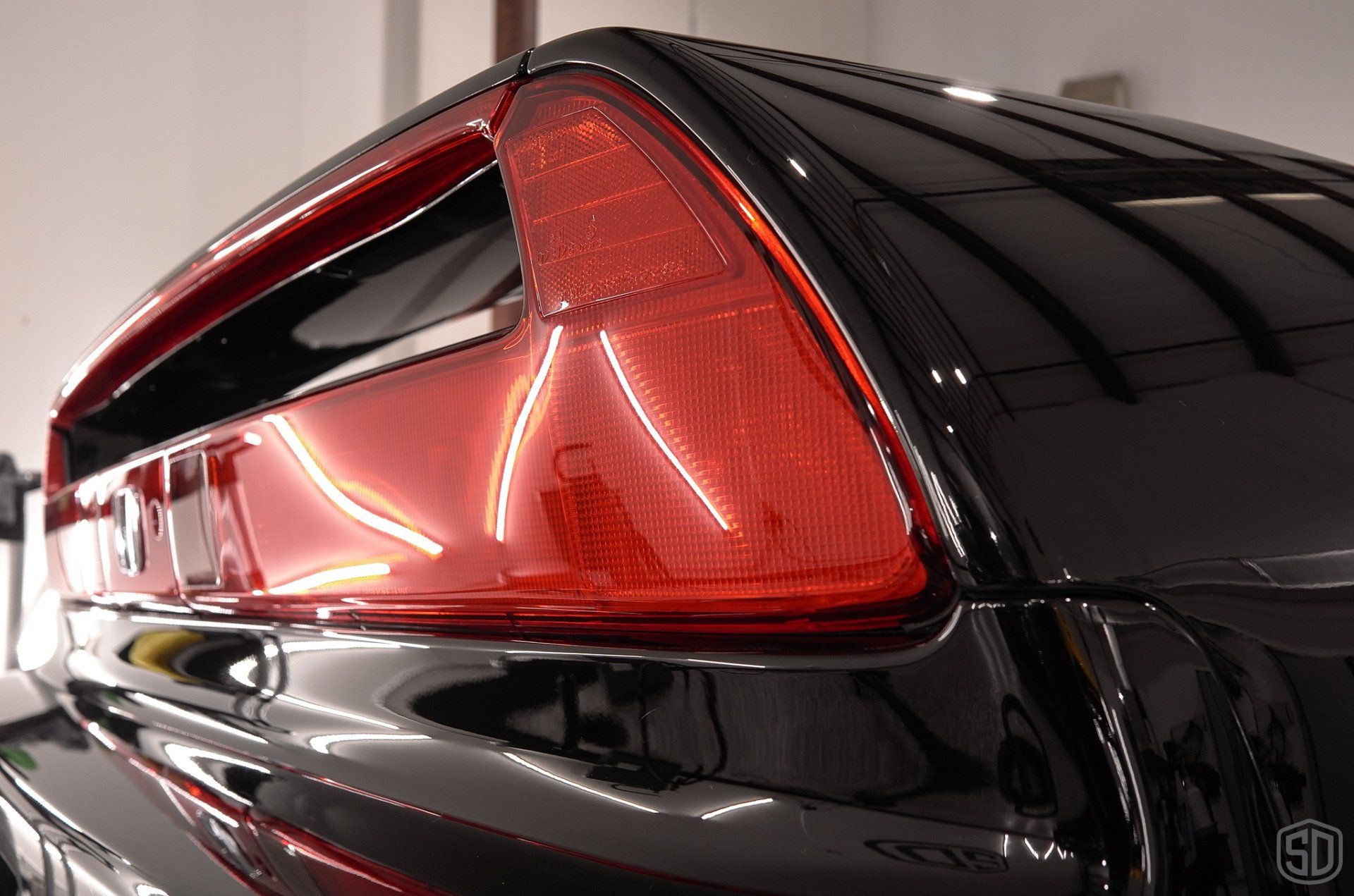 A close up of a black car with a red tail light