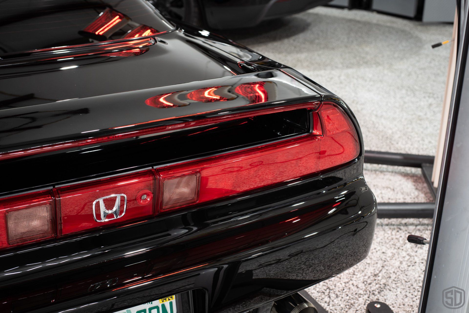 A black honda nsx is parked in a garage.
