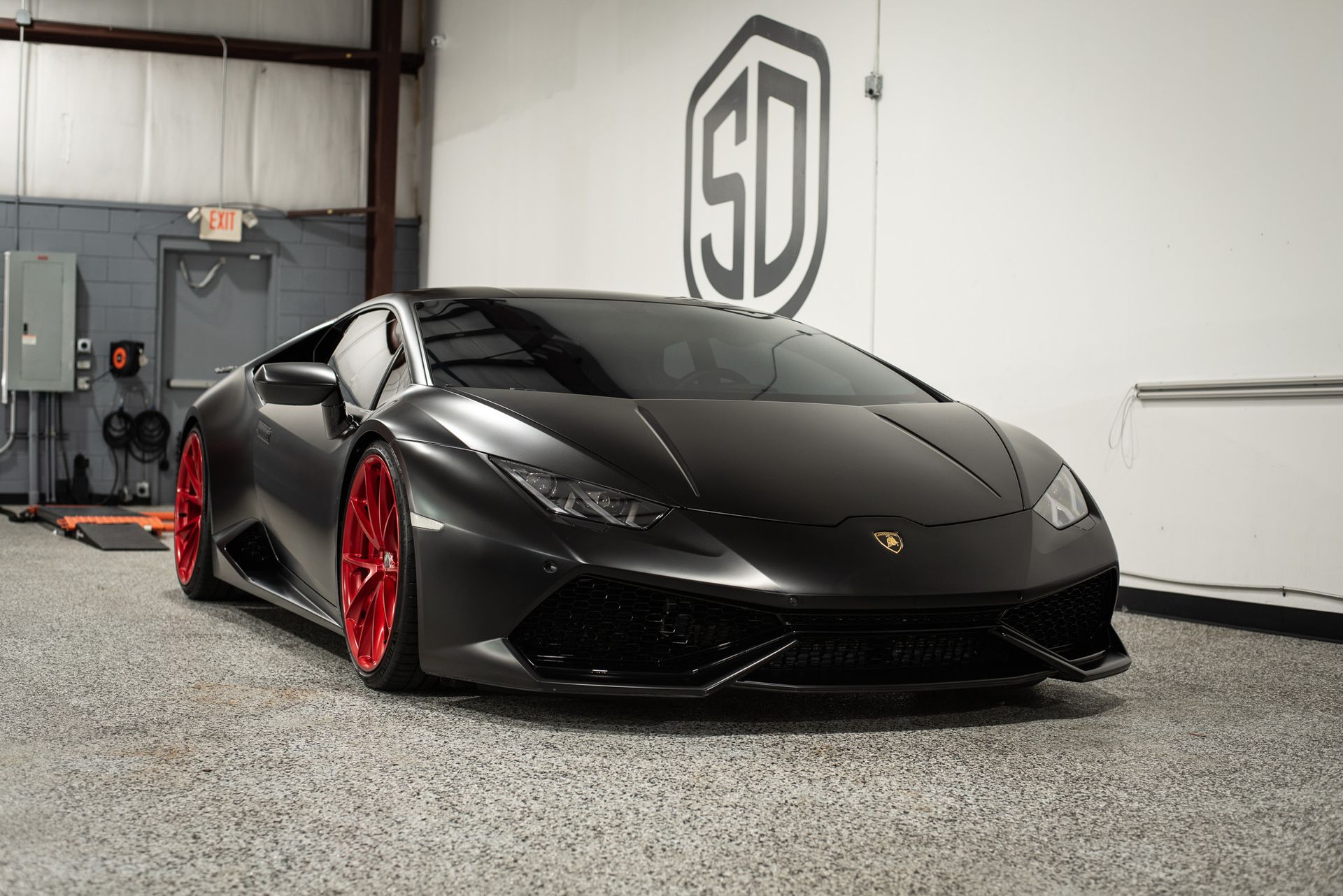 A black lamborghini huracan is parked in a garage.