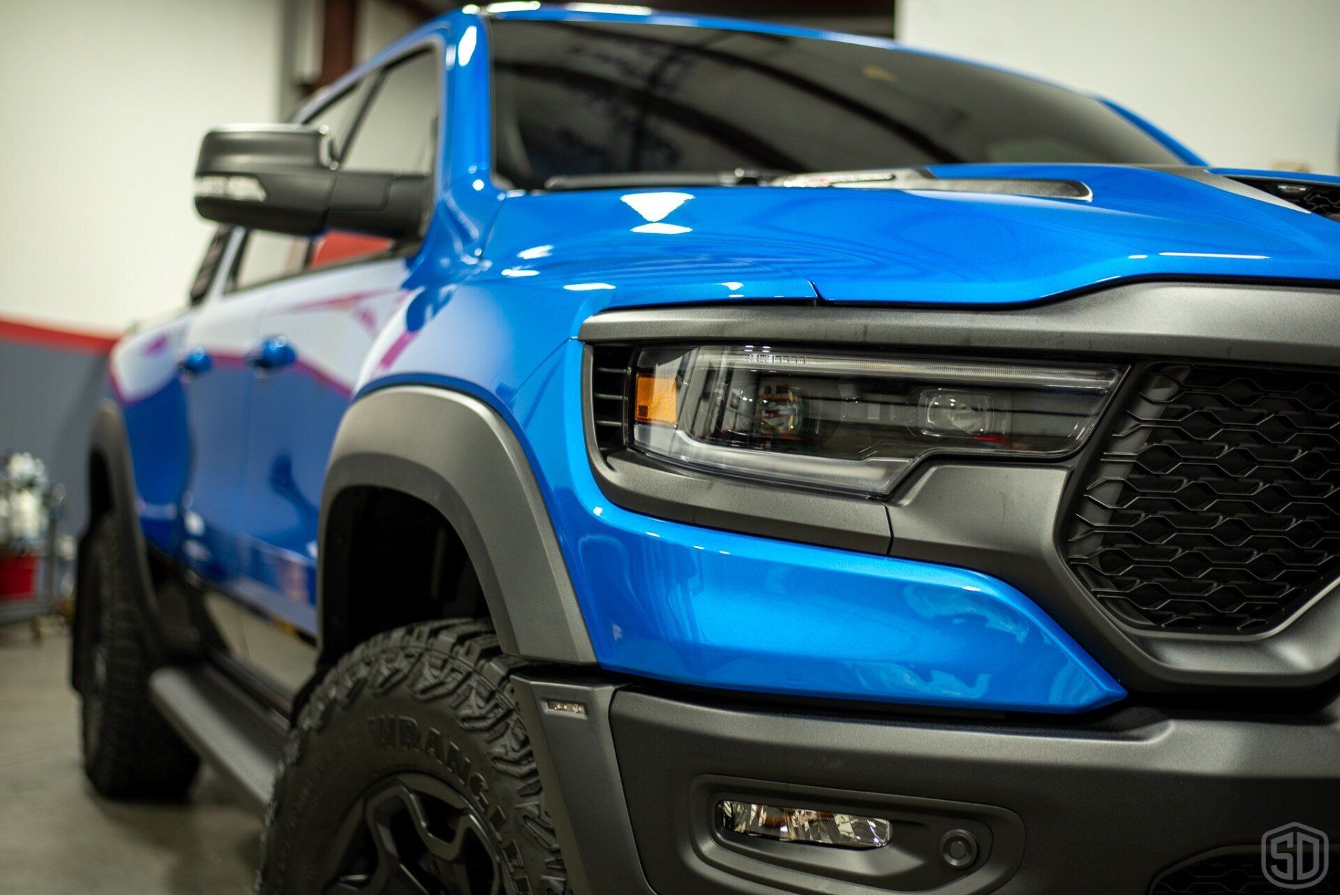 A blue ram truck is parked in a garage.