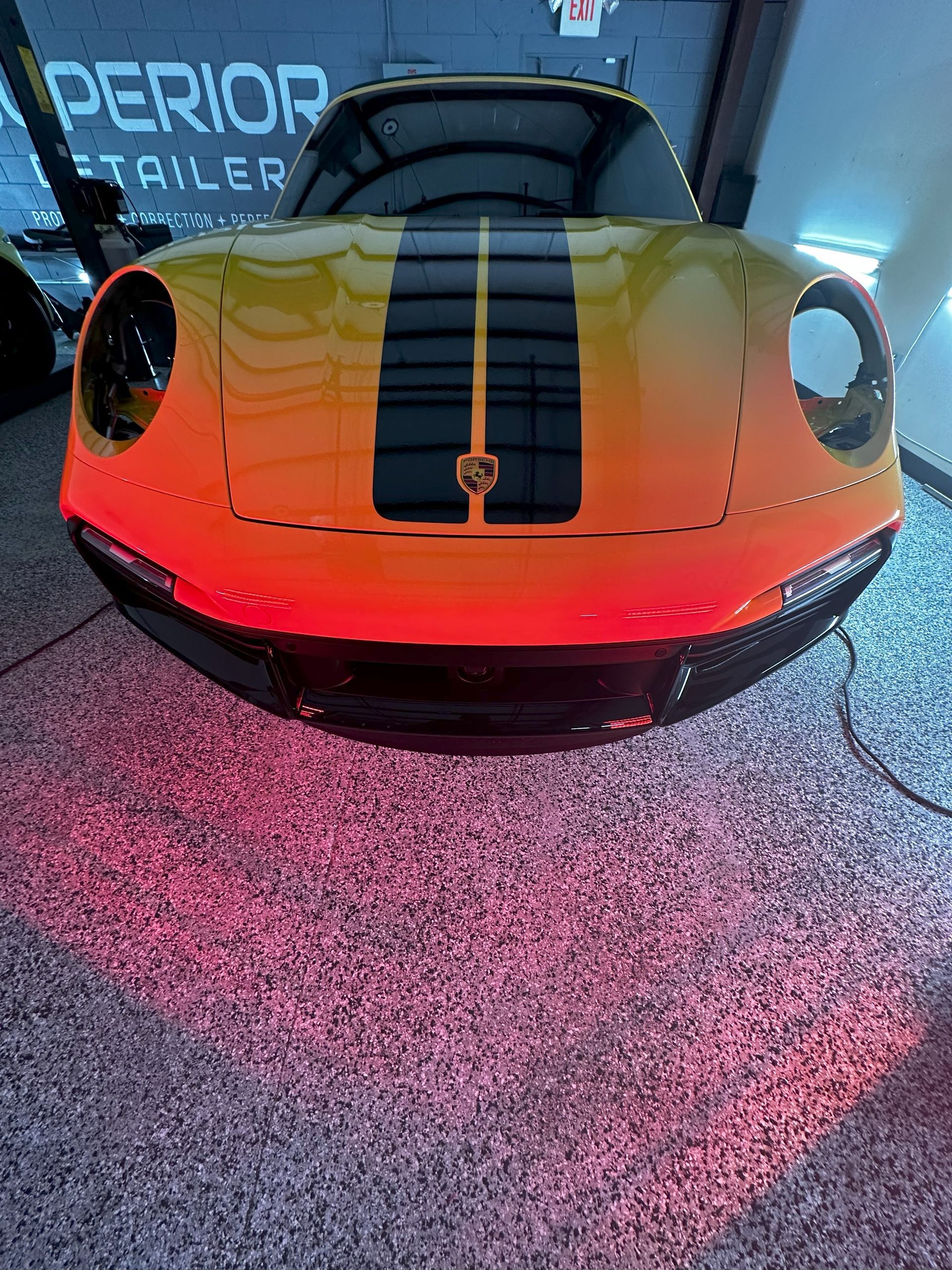 A yellow and black sports car is parked in a garage.