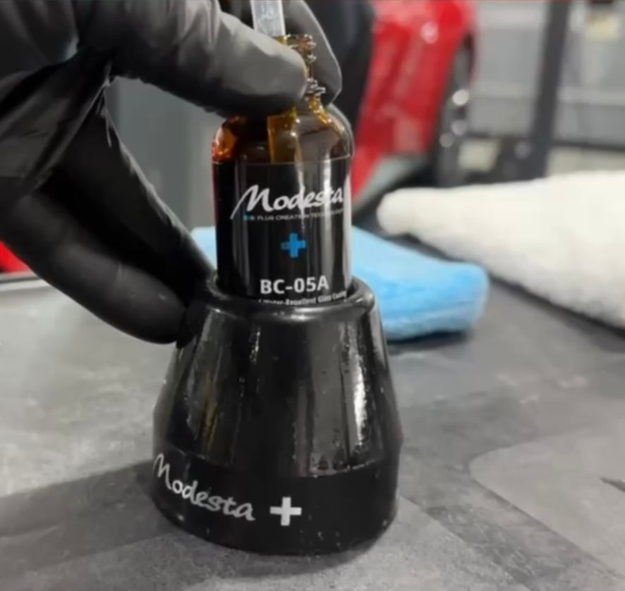 A person is holding a bottle of modestia bc- 05a