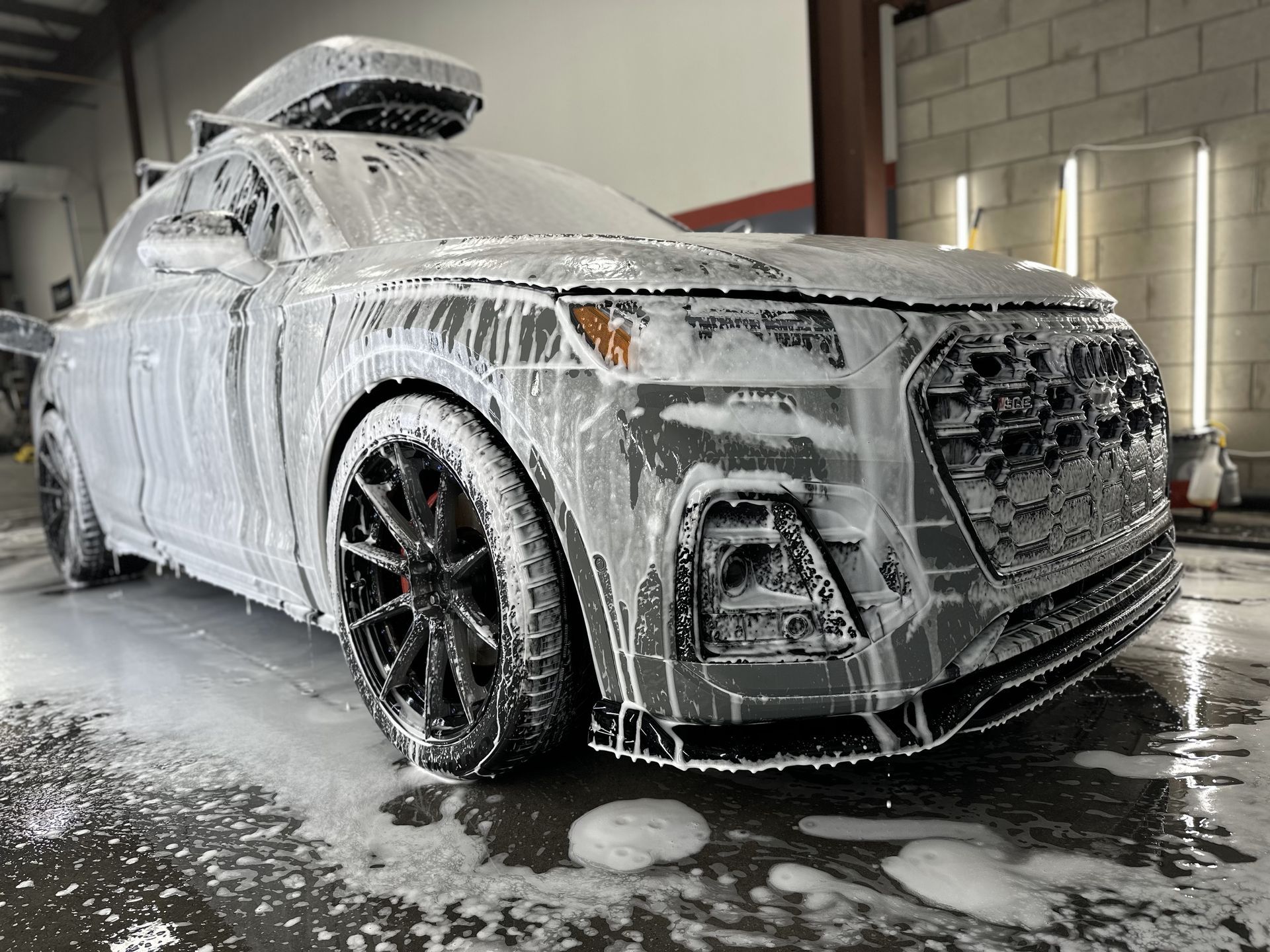 A car is covered in foam at a car wash.