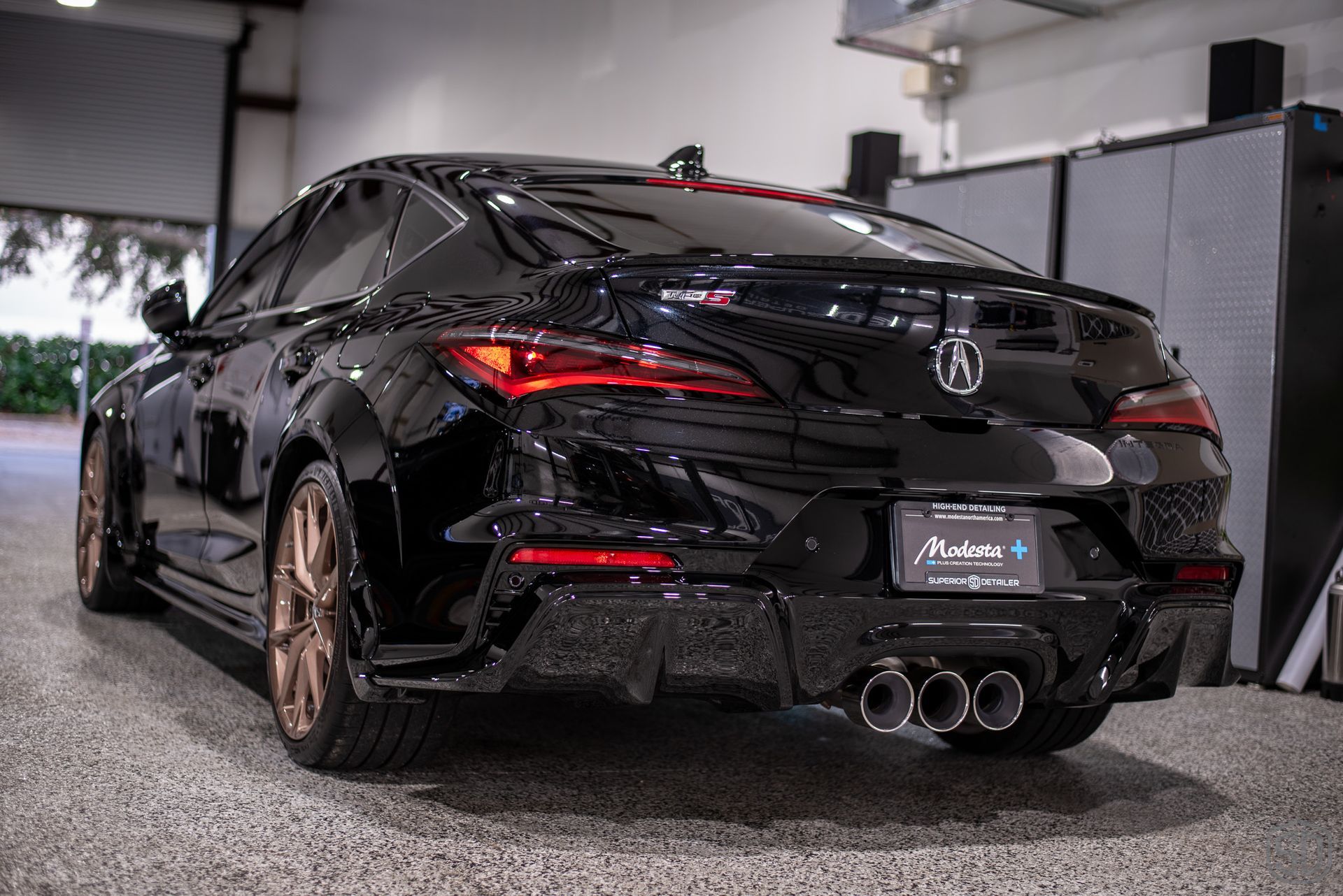 A black car is parked in a garage.