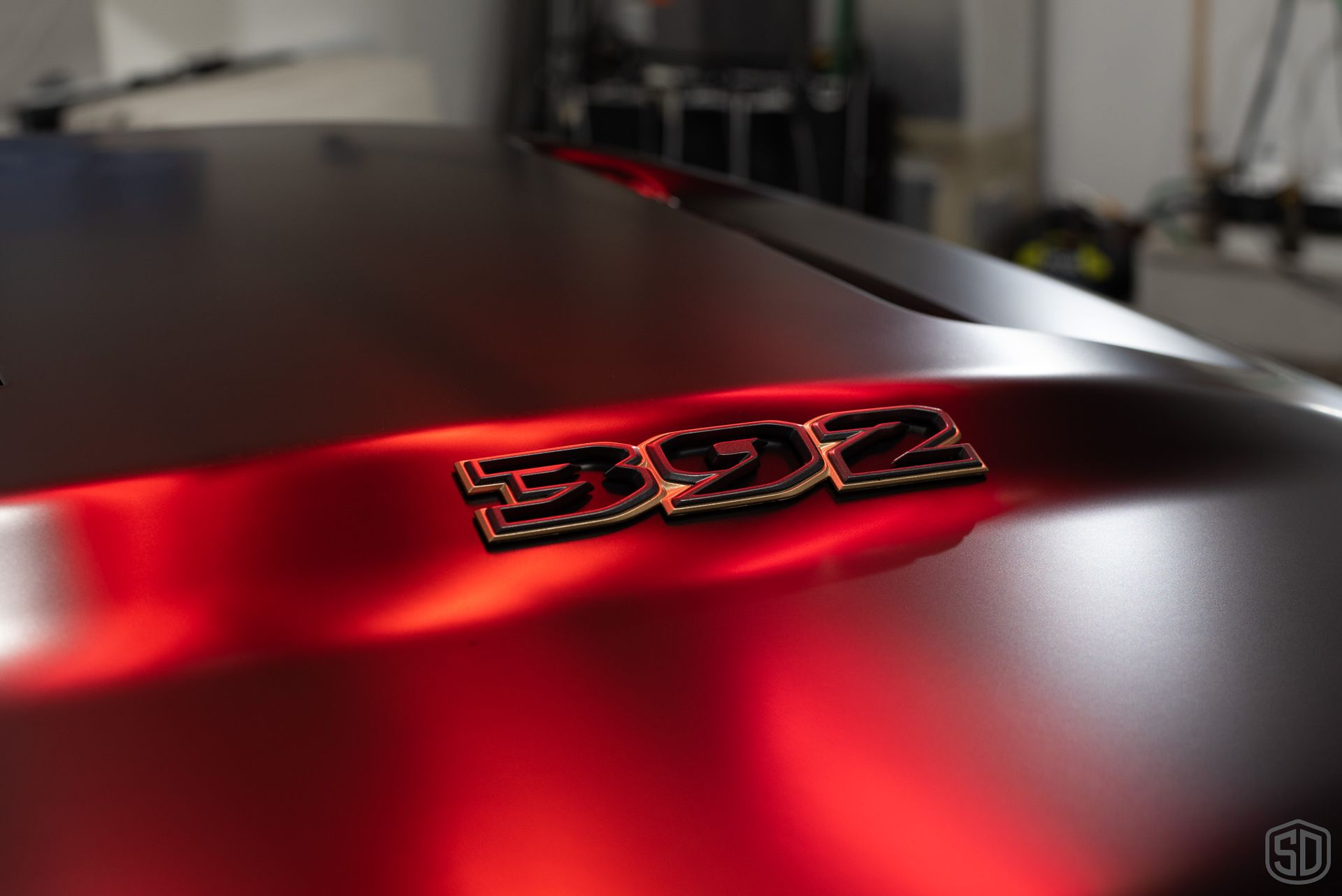A close up of the hood of a red dodge ram.
