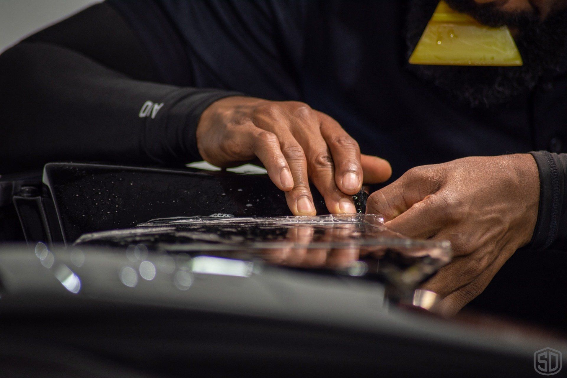 A man is working on a piece of glass with his hands.