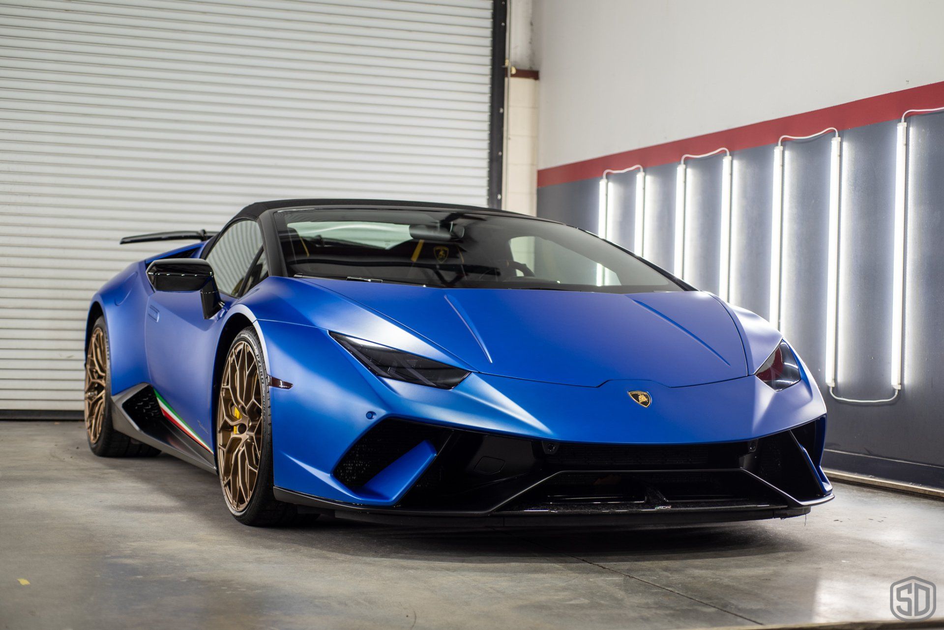 A blue lamborghini huracan is parked in a garage.