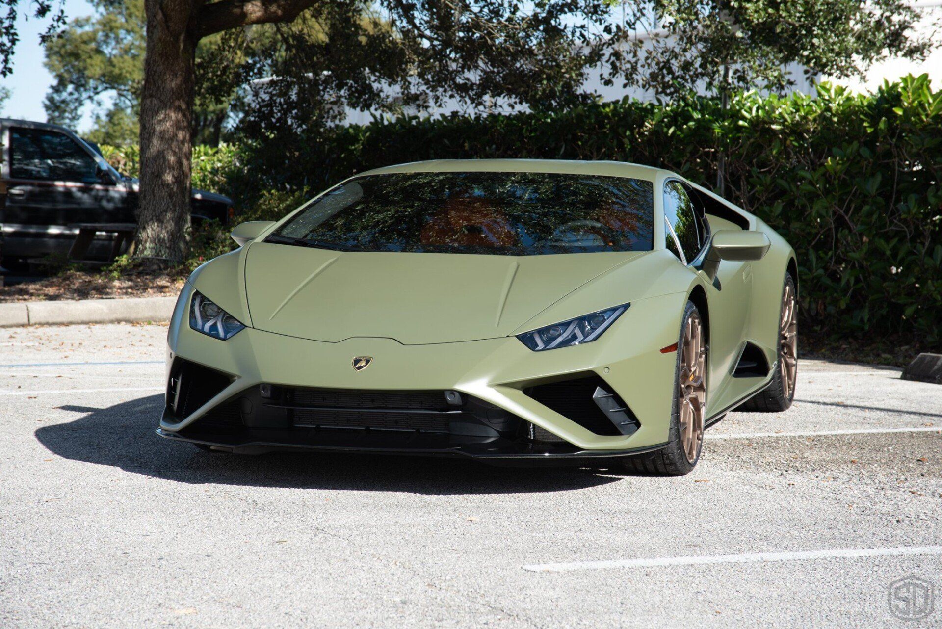 A green lamborghini huracan is parked in a parking lot.
