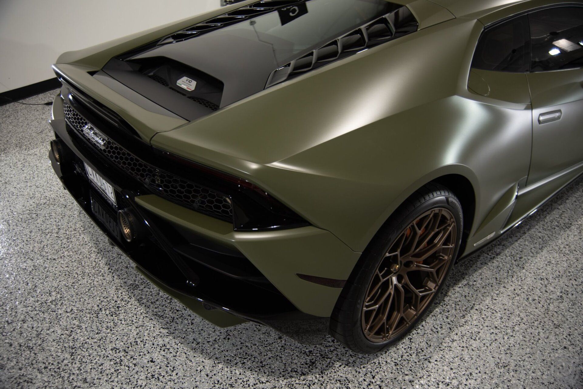 A green lamborghini huracan is parked in a garage.