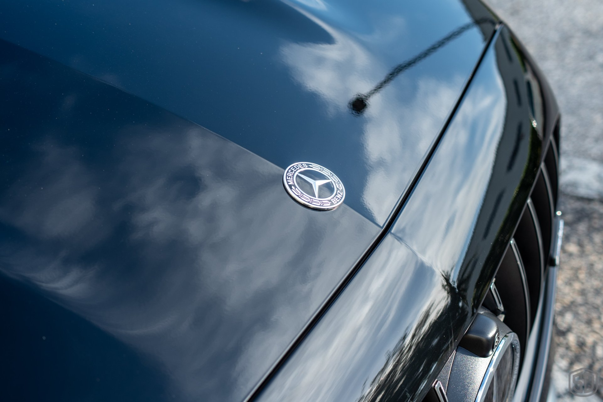 A close up of the hood of a black mercedes benz car.