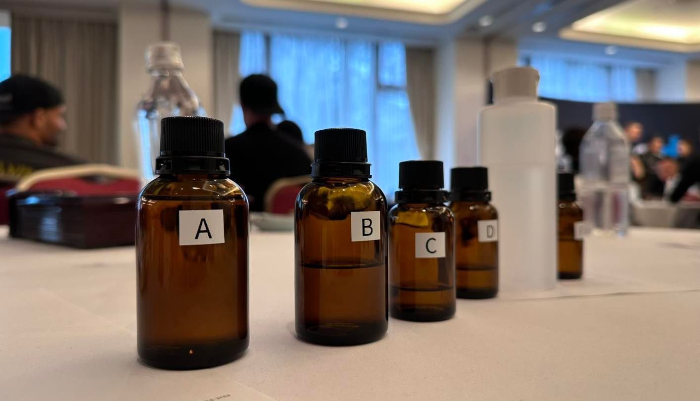 A row of bottles with labels on them are sitting on a table.