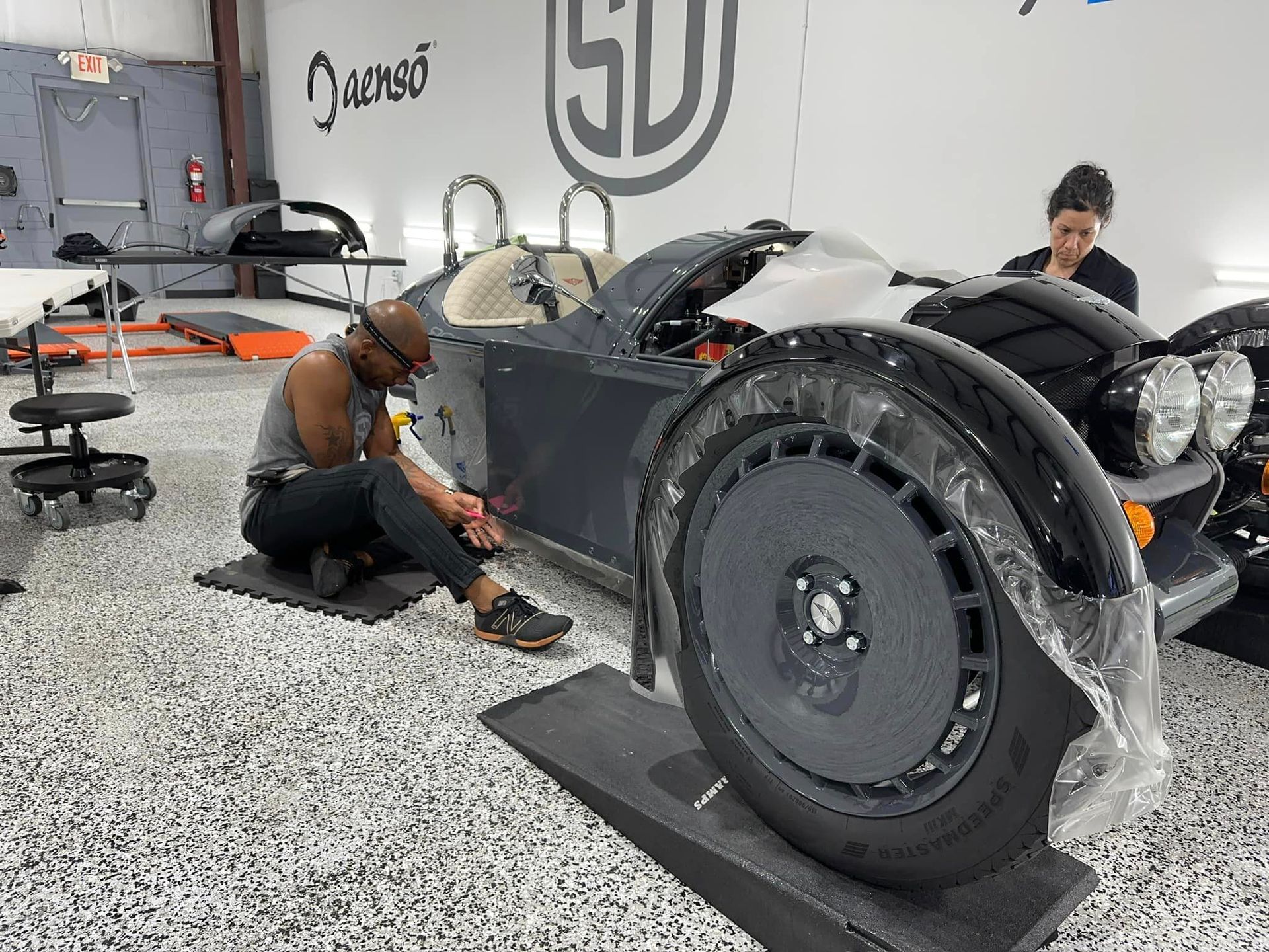 A man is working on a car in a garage.