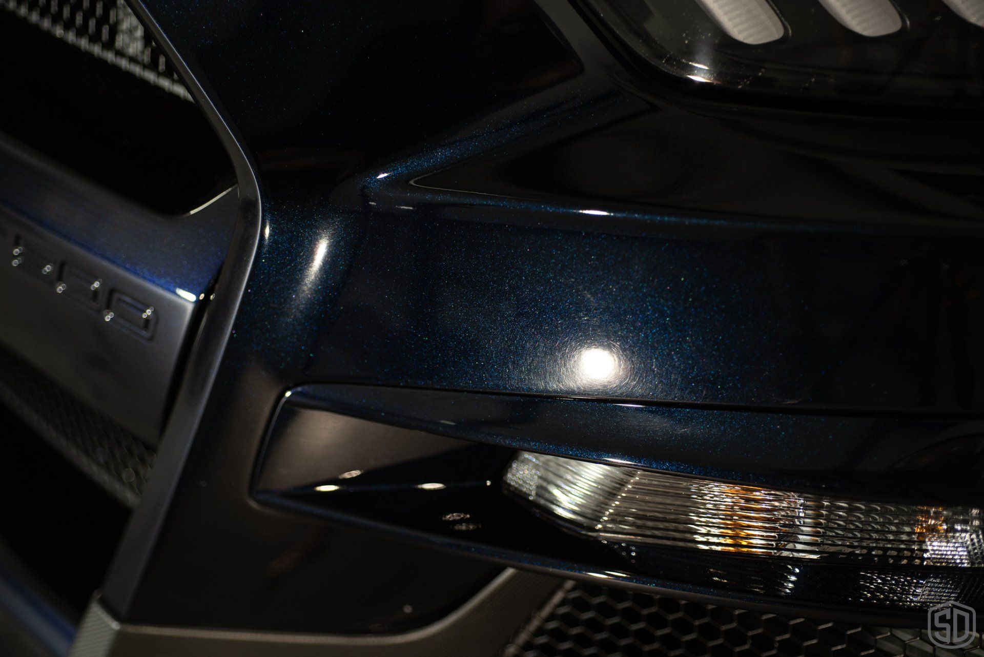 A close up of the front end of a blue ford mustang